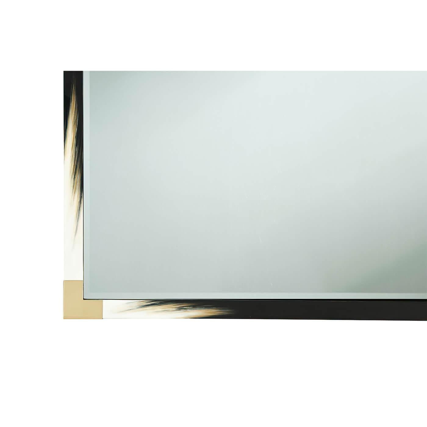 A large modern black lacquered and faux horn mirror, the rectangular top with brass edged corners, enclosing a beveled edge plate.
Dimensions: 54: W x 1.75