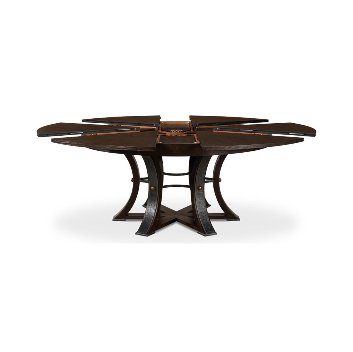 A modern industrial style round extending dining room table. Wire brushed oak top in our Burnt Brown finish with gunmetal iron accents to the simple geometric form base. The table opens and extends to 84