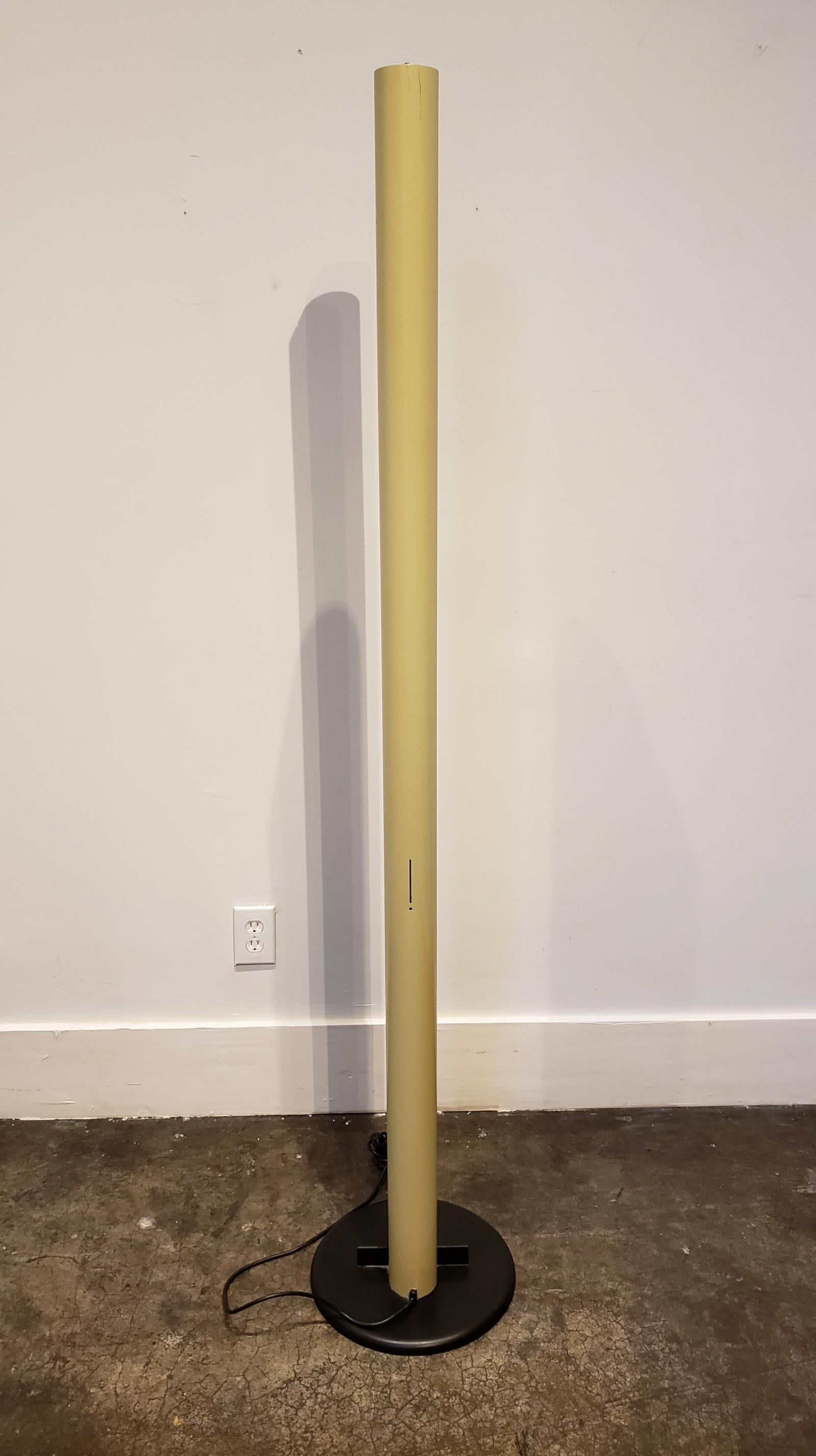 Floor lamp designed and manufactured in Italy, circa 1980s. Tall, enameled steel in tan color, oval shape with split down the middle, raised on black 14