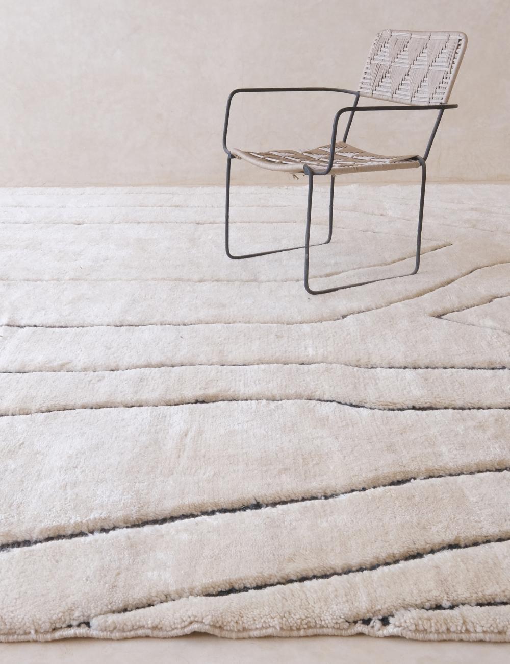Ce grand tapis marocain blanc tissé à la main a été fabriqué à la main par des artisans qualifiés dans les montagnes de l'Atlas. Il est composé de laine M'Rirt de haute qualité et constitue la pièce d'apparat neutre parfaite, avec un design gravé