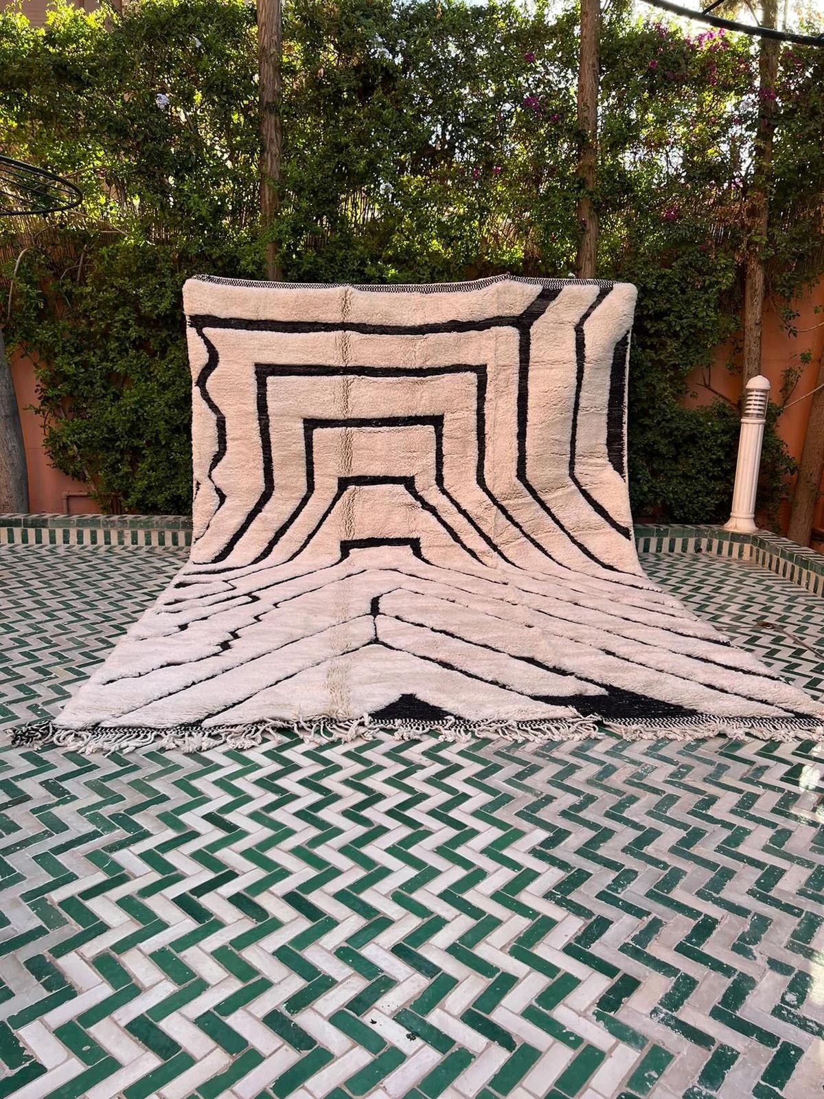 Ce grand tapis marocain crème tissé à la main a été réalisé sur un métier à tisser traditionnel par des artisans qualifiés dans les montagnes de l'Atlas. Il est fabriqué avec de la laine M'Rirt ultra luxueuse et de haute qualité. Il s'agit d'une