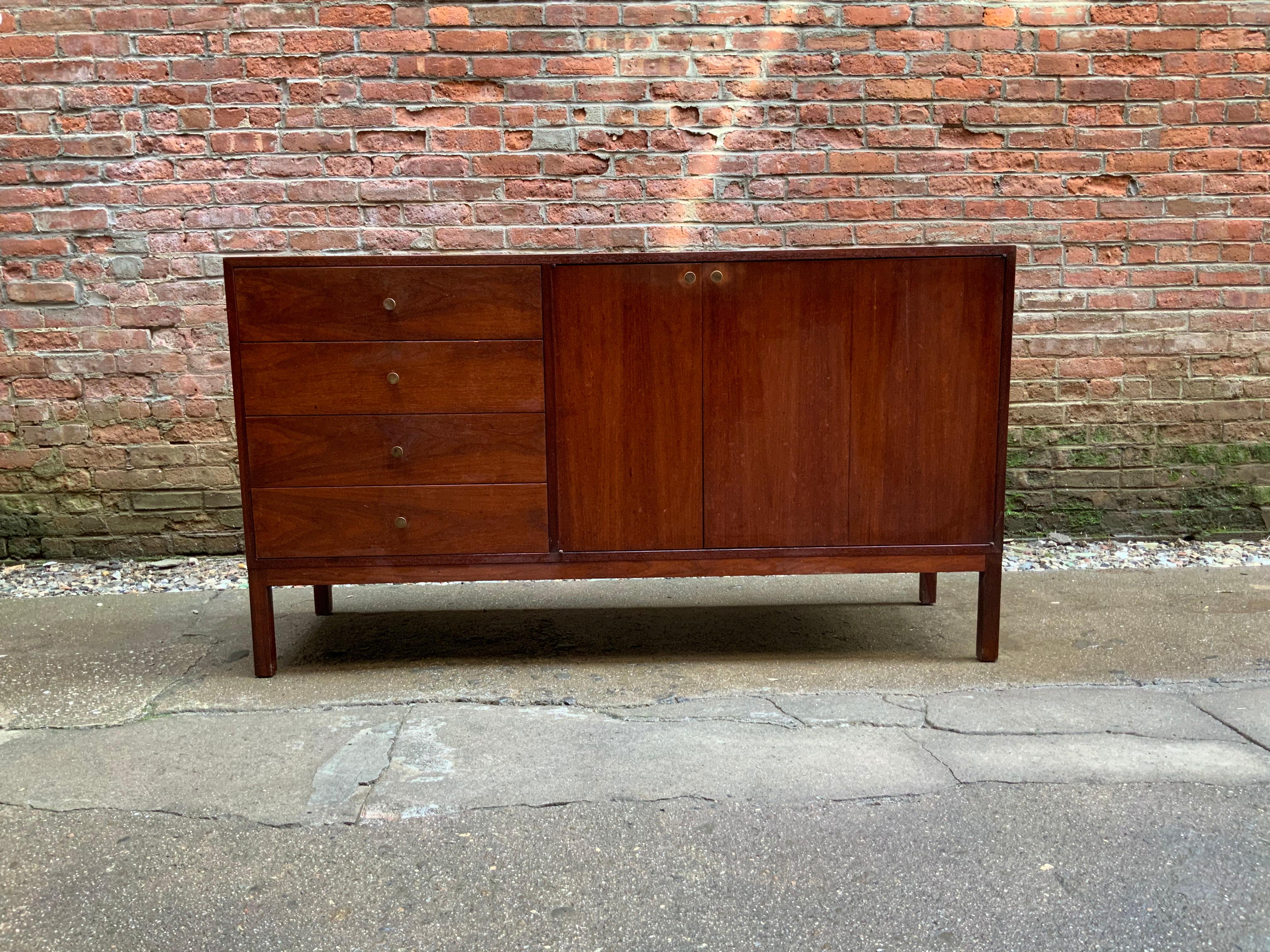 Four deep drawers flanked by two doors with four interior drawers. Brass hardware. Low luster oiled walnut veneers, circa 1960. Reminiscent of Jens Risom or Milo Baughman for Arch Gordon design. Very good condition.

Measures: Approximately 18