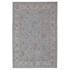 Grand tapis d'Oushak à motifs floraux et tons colorés discrets sur fond neutre