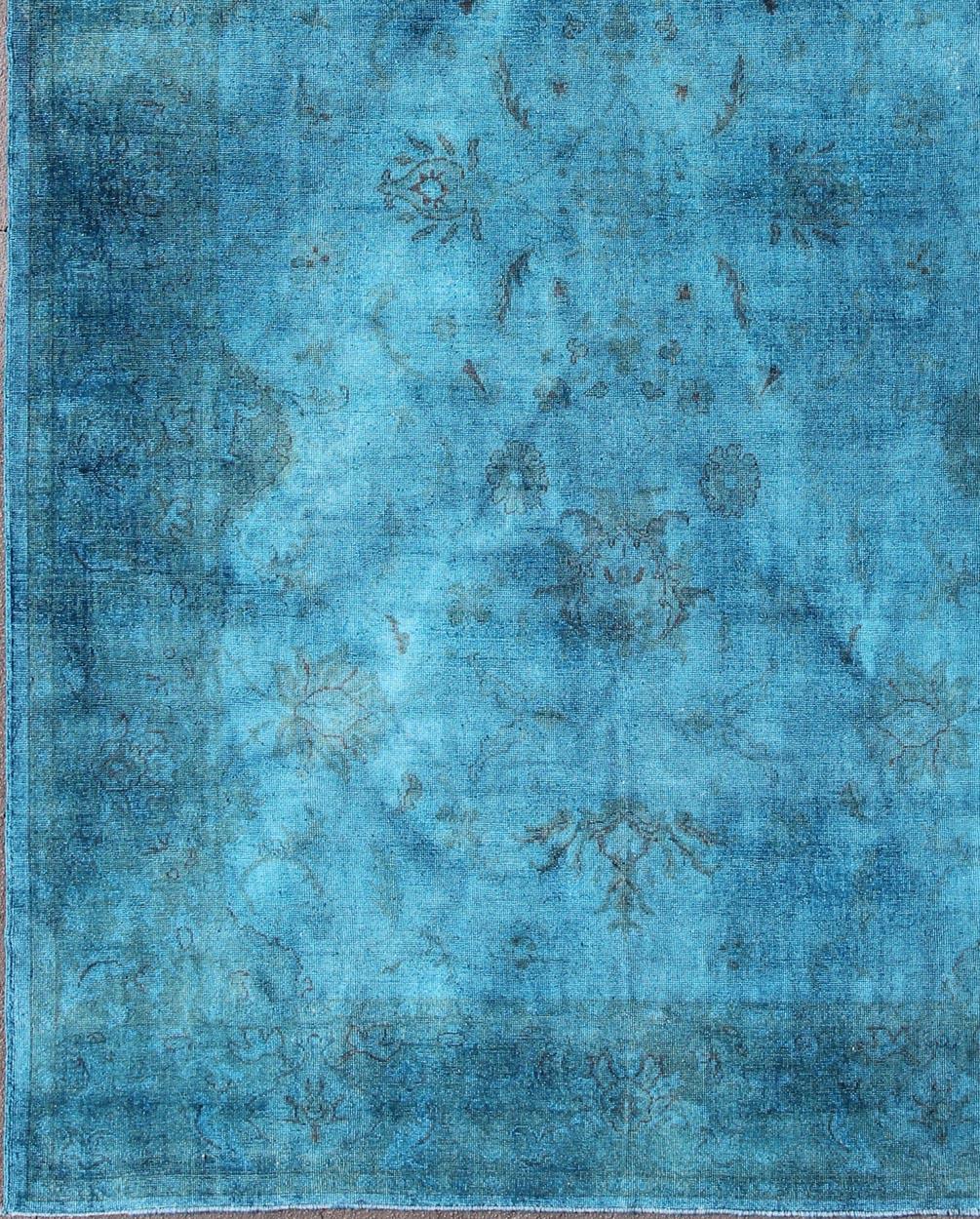 This modern Turkish carpet with a classical composition has been over-dyed with blue, light blue pigments. With both classic and contemporary characteristics, this beautiful carpet could perfectly adorn a transitional or a contemporary and modern