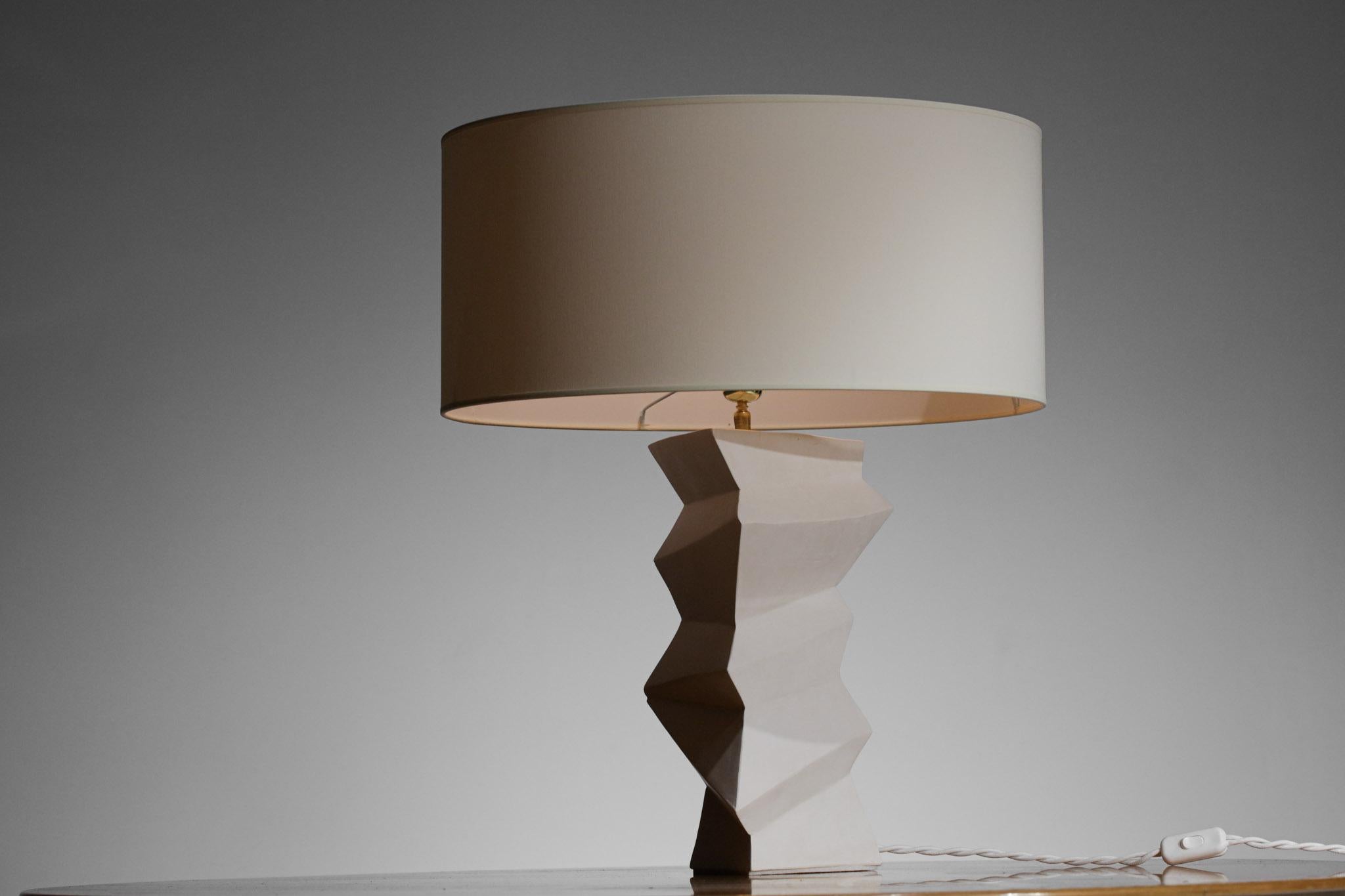 Modern French desk or bedside lamp in the style of Giacometti. Handcrafted, white plaster triangular faceted structure of the base, new custom-made lampshade. Imposing lamp is sculptural and very decorative. Excellent condition (see photos).