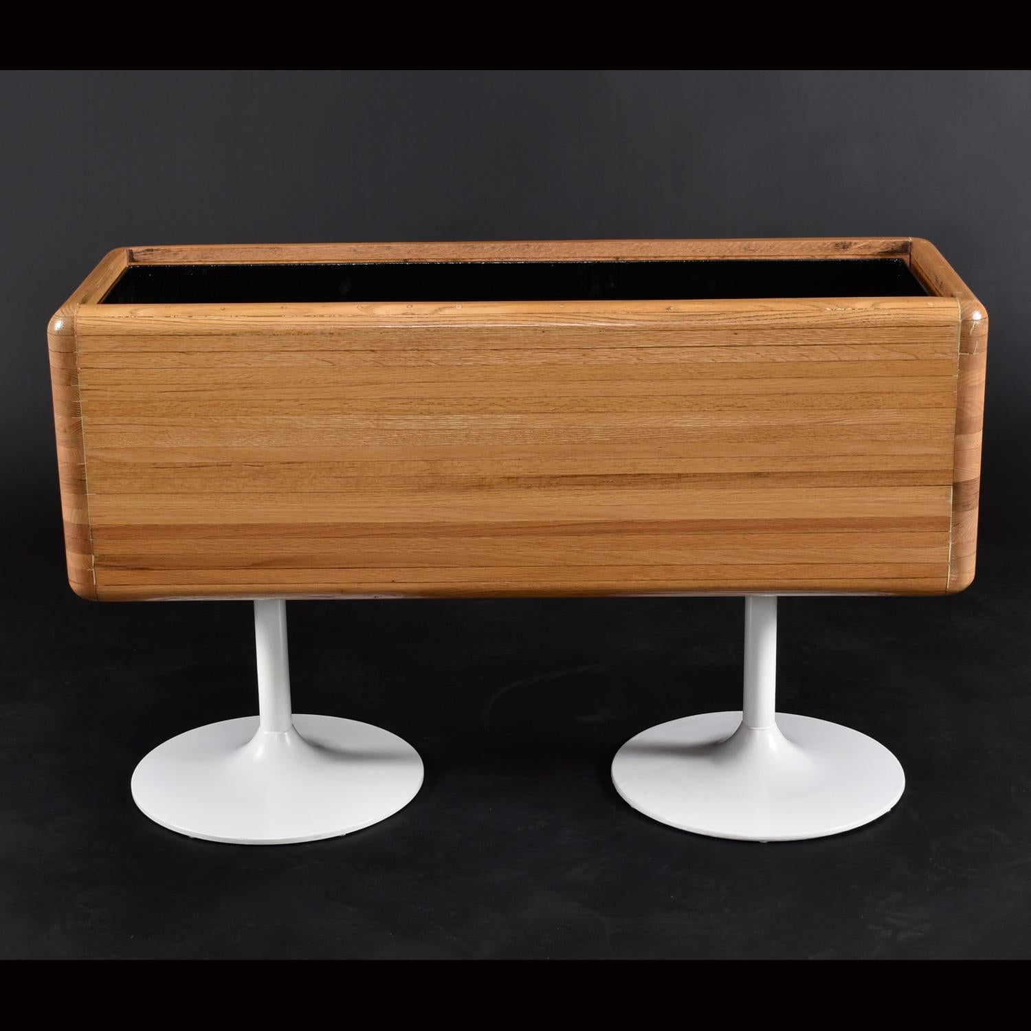 Large Mid-Century Modern refinished solid oak planter on twin Saarinen style tulip bases. This is a one-of-a-kind piece, you won’t find another. Our in-house design and restoration team created this piece from authentic vintage parts. The planter is