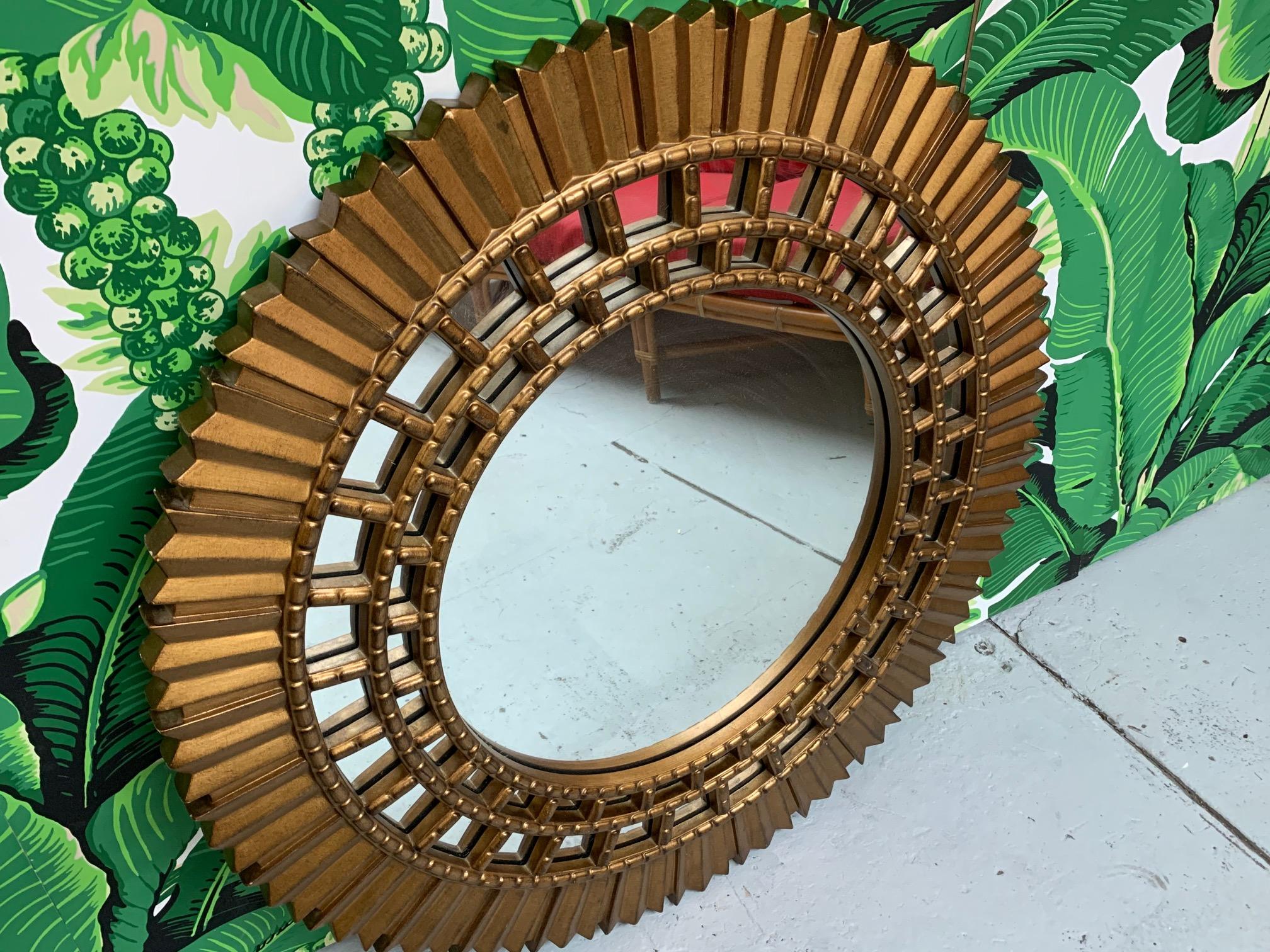 Large sunburst mirror features faceted resin frame and modern, Art Deco style rays. Good vintage condition with minor imperfections consistent with age.