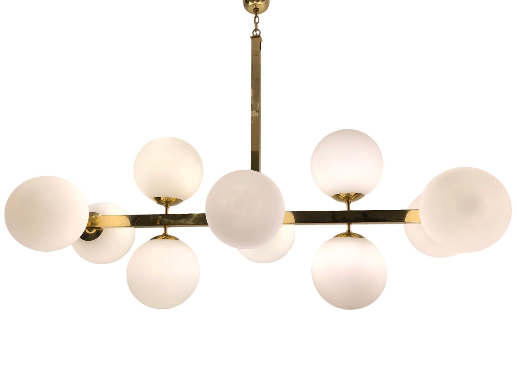 A large circa 1960s Italian moderne horizontal light fixture with polished bronze finish and ten over-sized globe lights.

Measurements:
Minimum drop 36