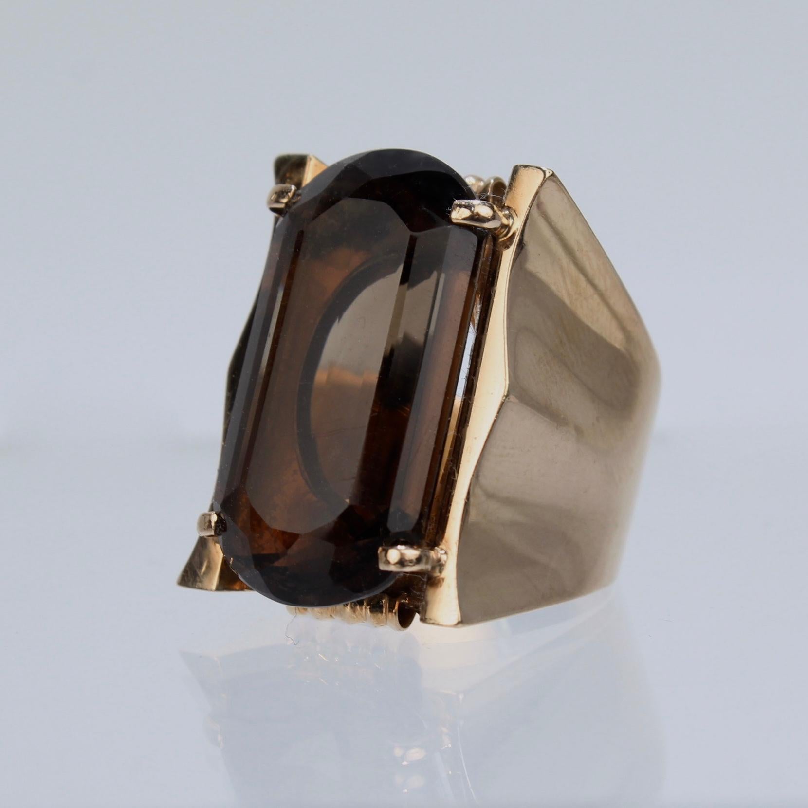 A modernist cocktail ring.

In 18K yellow gold with a large smoky quartz gemstone prong set in a large, shaped setting.

Simply a great signet style ring!

Date:
1980s

Overall Condition:
It is in overall good, as-pictured, used estate condition