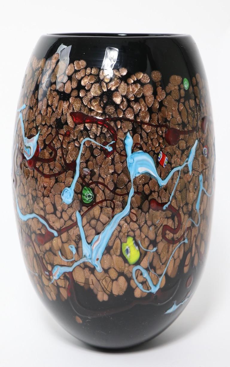 Impressive Murano glass vase having gold inclusion, colorful abstract elements and murrines. The vase appears to have a black ground, but is in fact dark amethyst ( see images ). No damage, chips, cracks, or repairs, retains original foil label