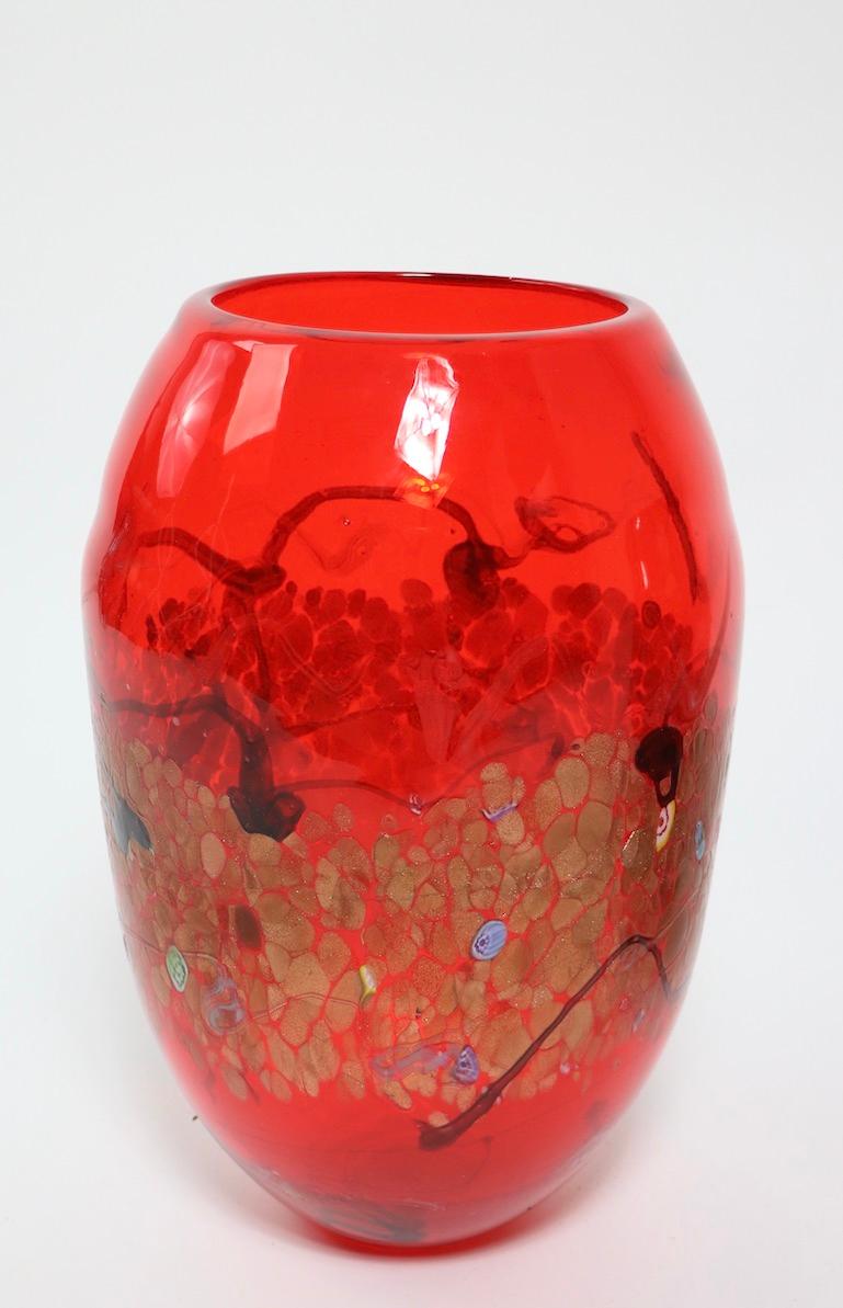 Impressive Murano glass vase having gold inclusion, colorful abstract elements, and murrines on an orange ground. The vase retains its' original foil label which reads cristalleria d'arte Murano.