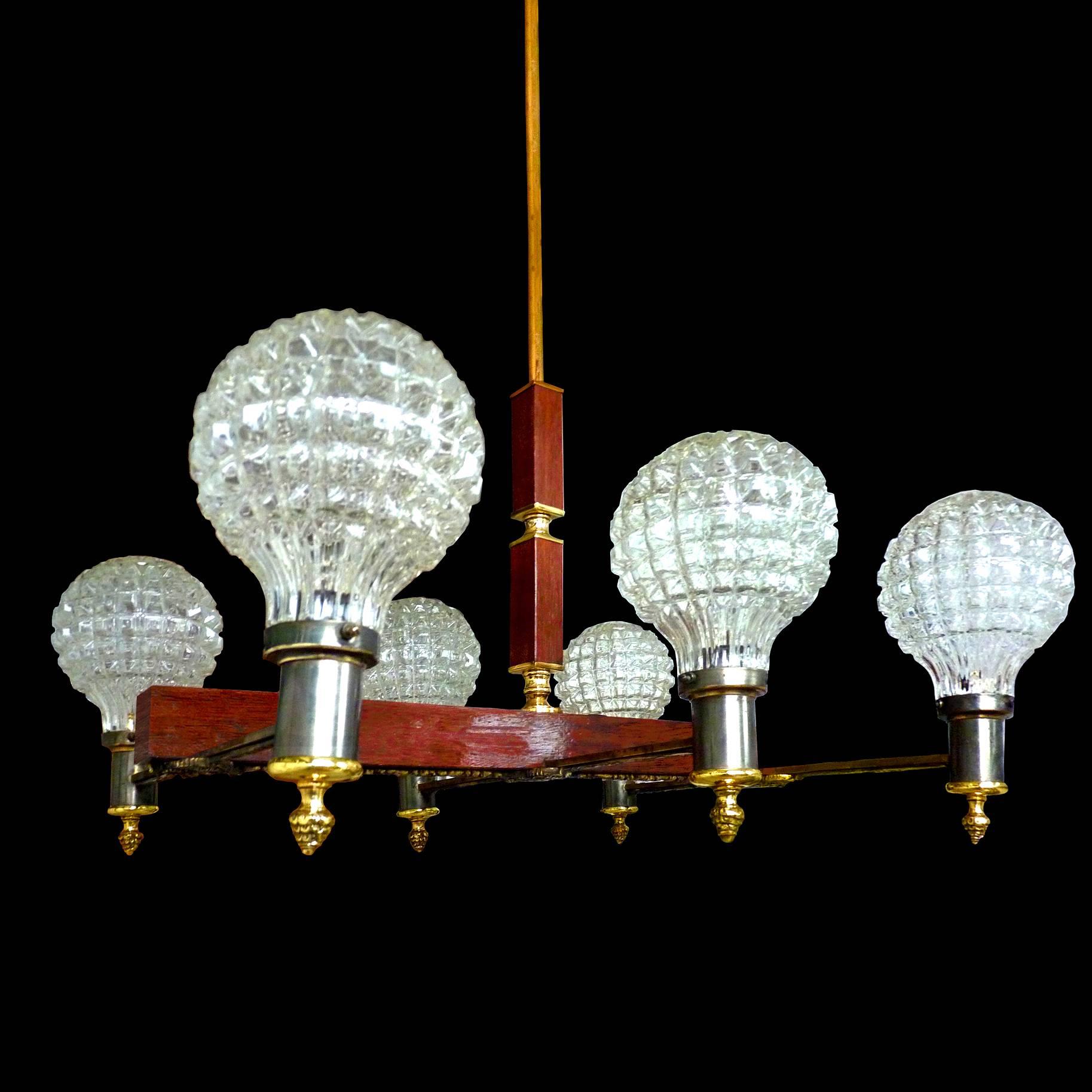 Unusual French Art Deco in engraved bronze and brass on wood with 6-light ice glass shades chandelier, circa 1940.
  