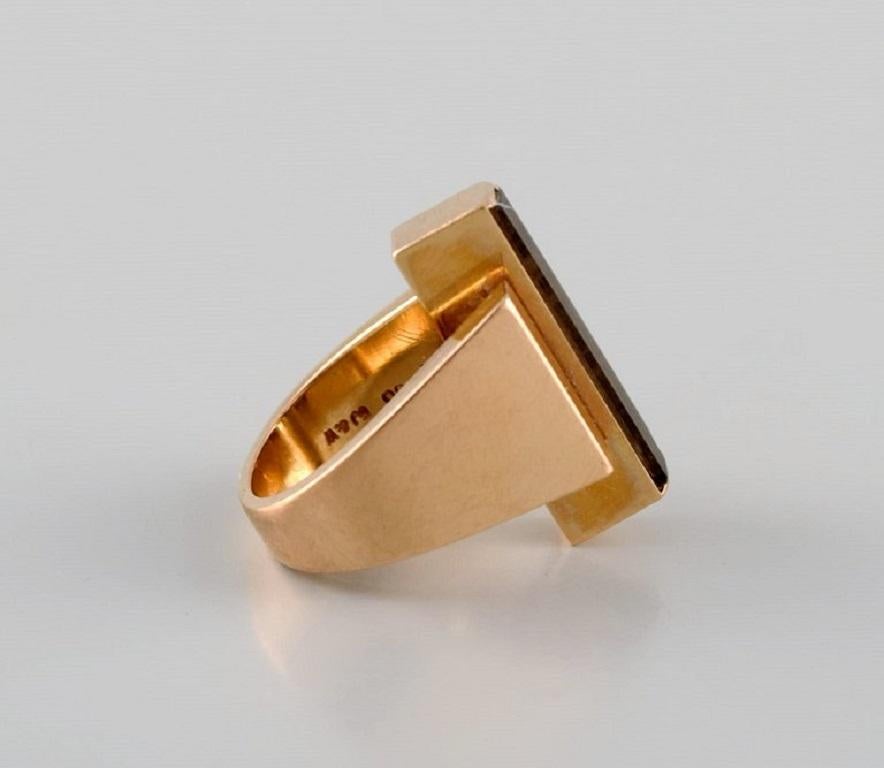 Large modernist Georg Jensen ring in 18 carat gold adorned with smoky quartz. 
Dated 1945-1951.
Diameter: 16 mm.
US size: 5.5.
In excellent condition.
Stamped.
We can change the size for a fee (50 USD) per ring in most cases.