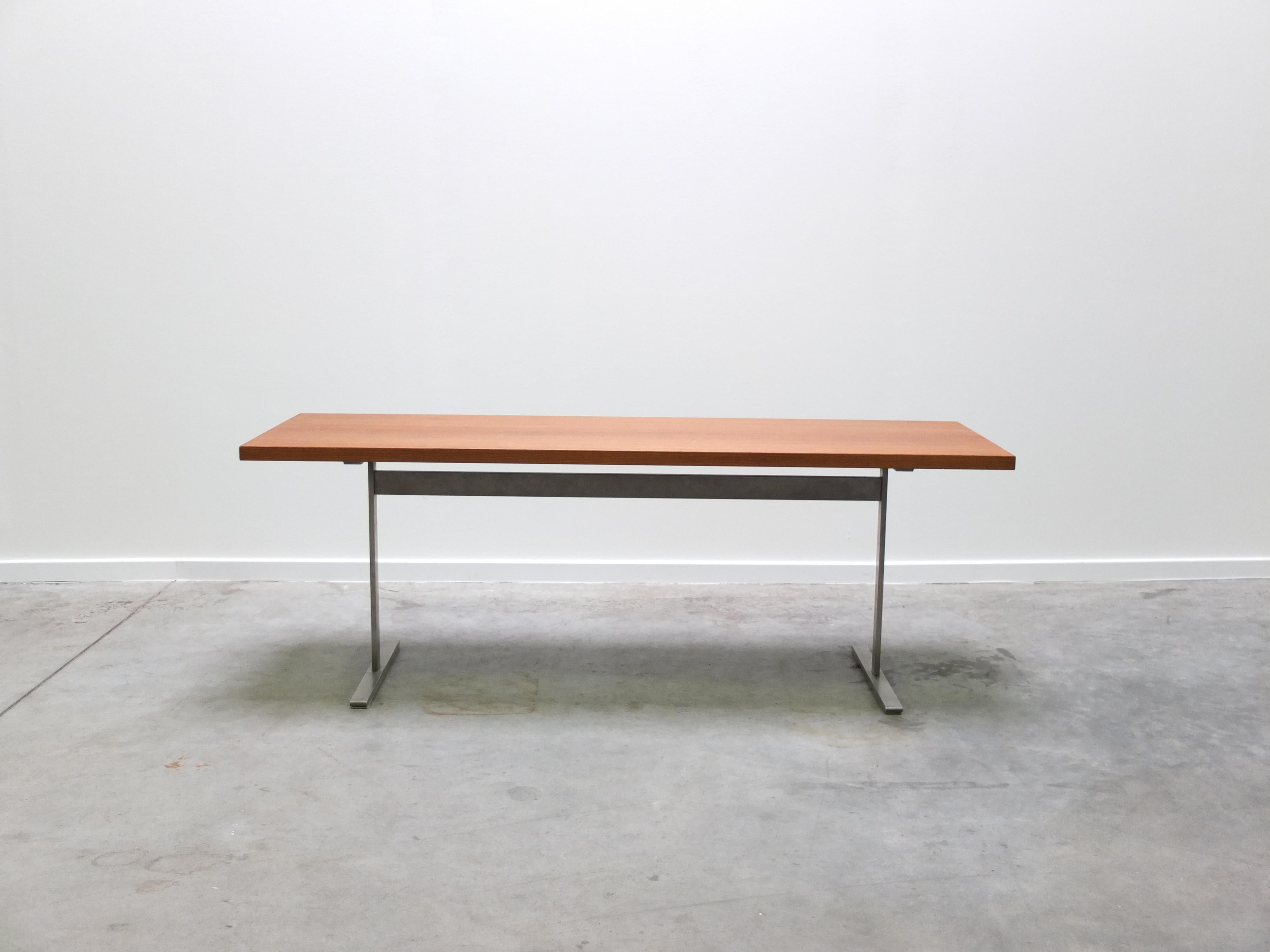 Table basse moderniste dans le style d'Arne Jacobsen avec une base en métal et un grand plateau rectangulaire en teck. Une production danoise de très haute qualité. Le dessus a été refini professionnellement. En très bon état.