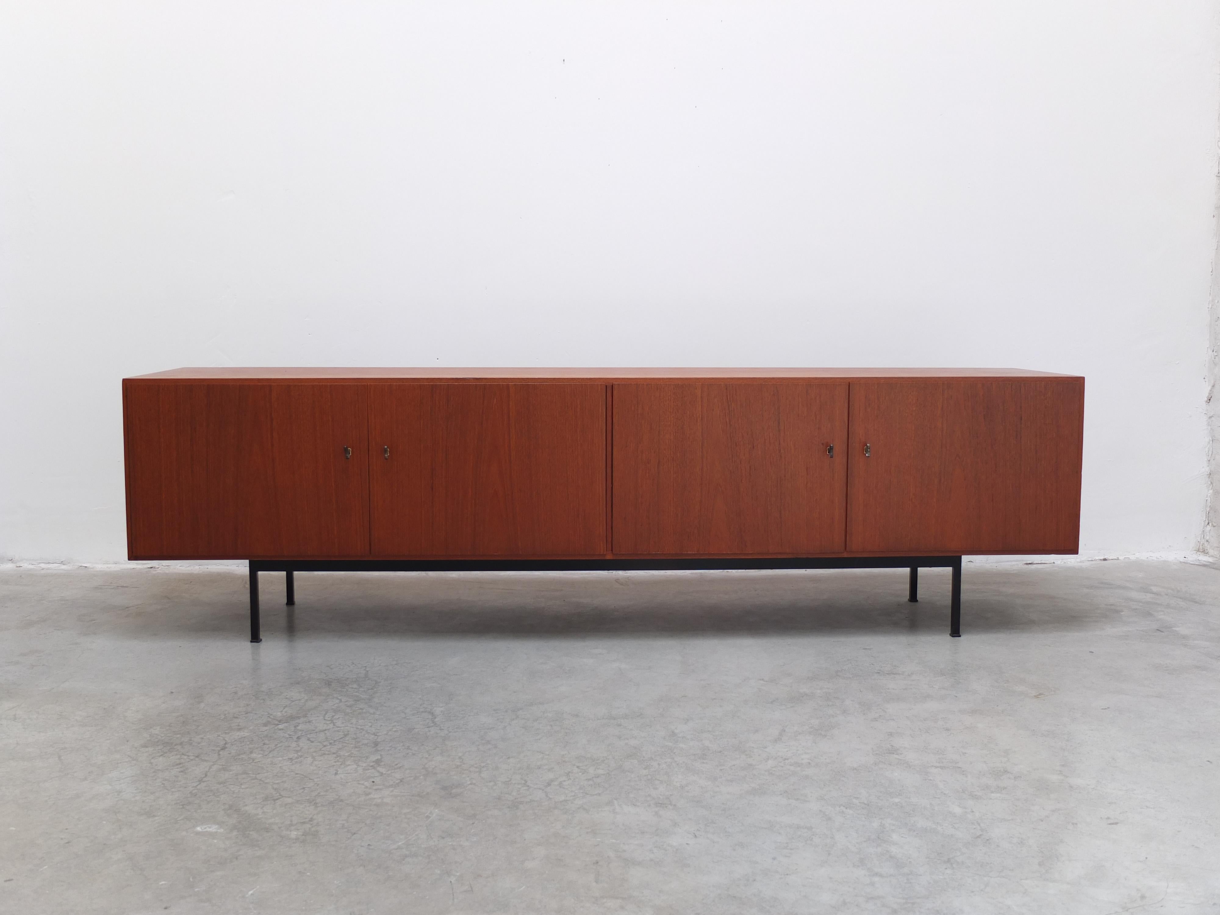 Magnifique buffet moderniste produit en Allemagne vers 1960. Le fabricant est actuellement inconnu mais ce modèle est clairement influencé par la célèbre série 'B40' de l'architecte suisse Dieter Waeckerlin reconnaissable à son design minimaliste et