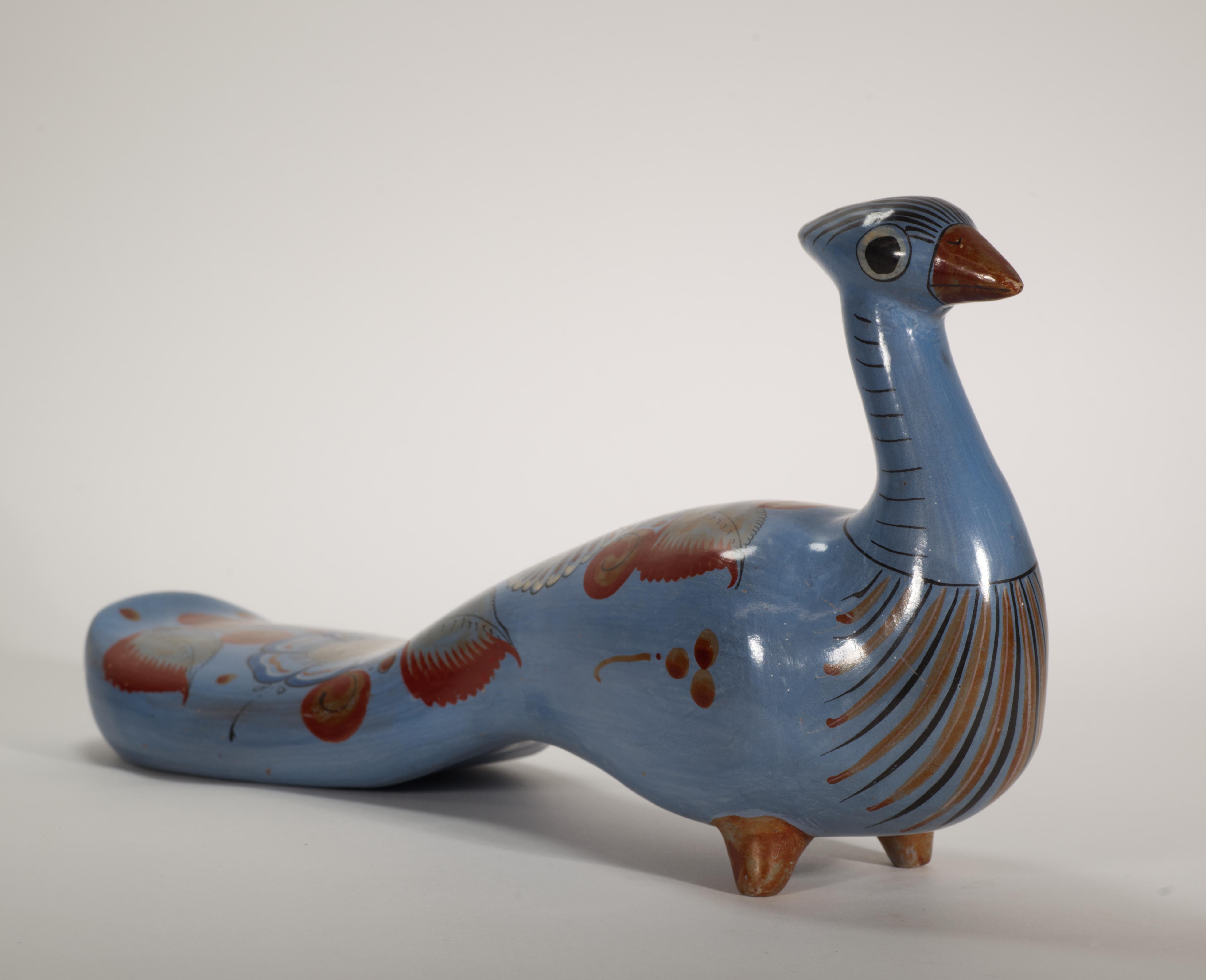  Unusual large bird sculpture features striking Modernist shape and elaborate, highly detailed hand-painted decor. Traditional Tonala abstract flowers and leaves motifs in white, rust orange, and deep blue palette on soft blue background flow along