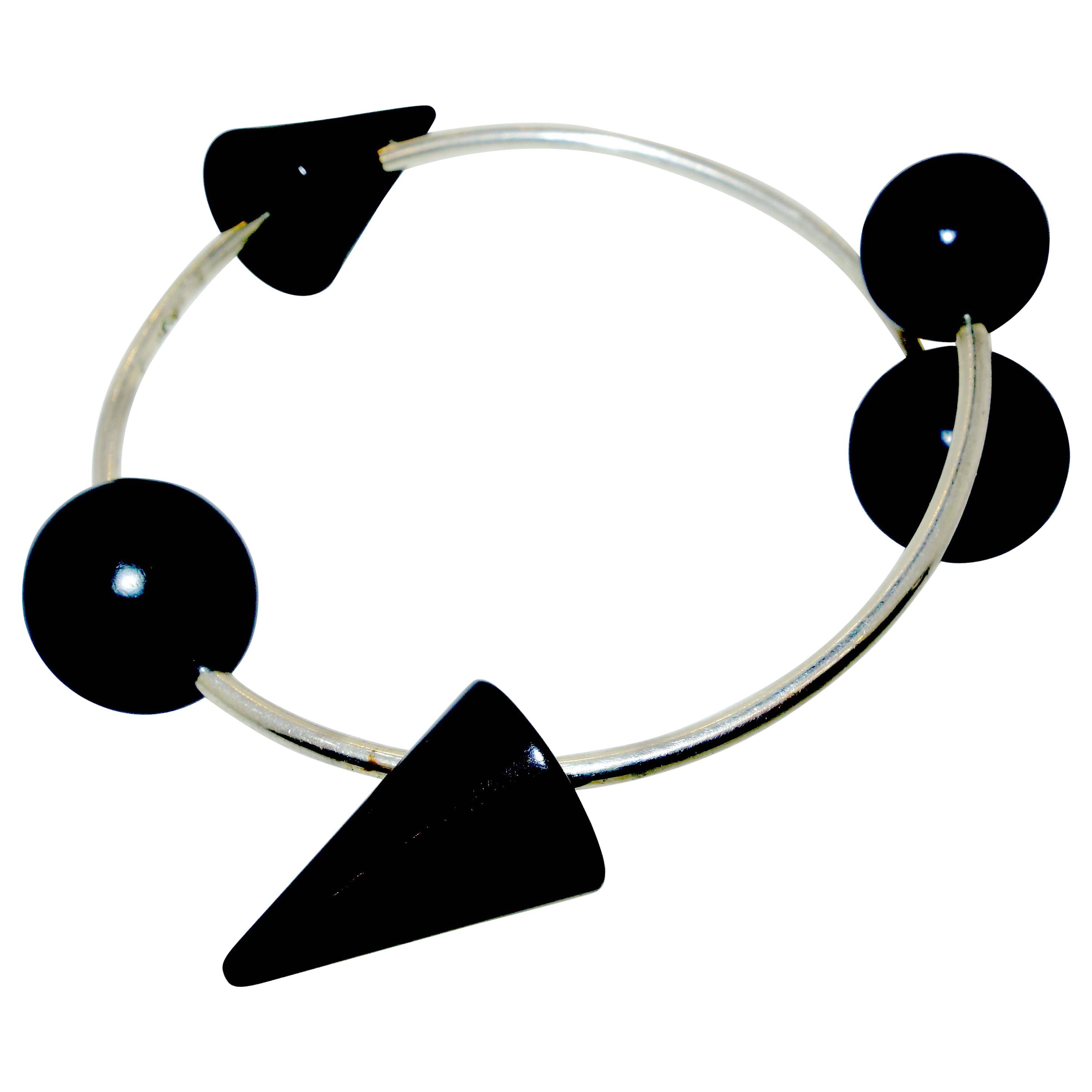 Bangle with a geometric design with black ceramic decorative elements (element's directions can be changed), set along a narrow tube of polished steel to create quite an unusual design. It expands slightly for ease of putting on. In excellent