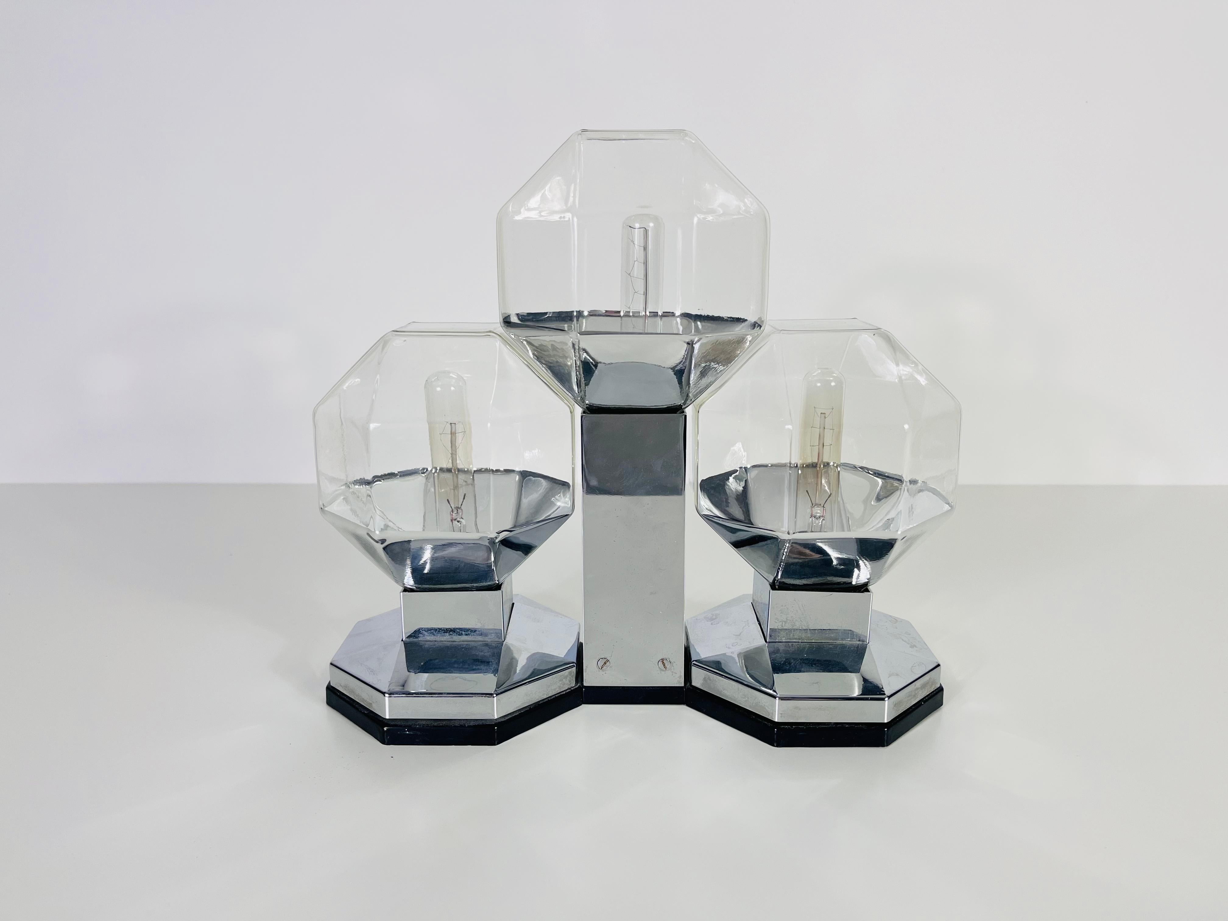 This versatile flush mount or table lamp, designed by renowned Japanese designer Motoko Ishii, is a striking piece from the esteemed German brand Staff Leuchten. It features three delicate glass shades, creating a sophisticated and elegant lighting