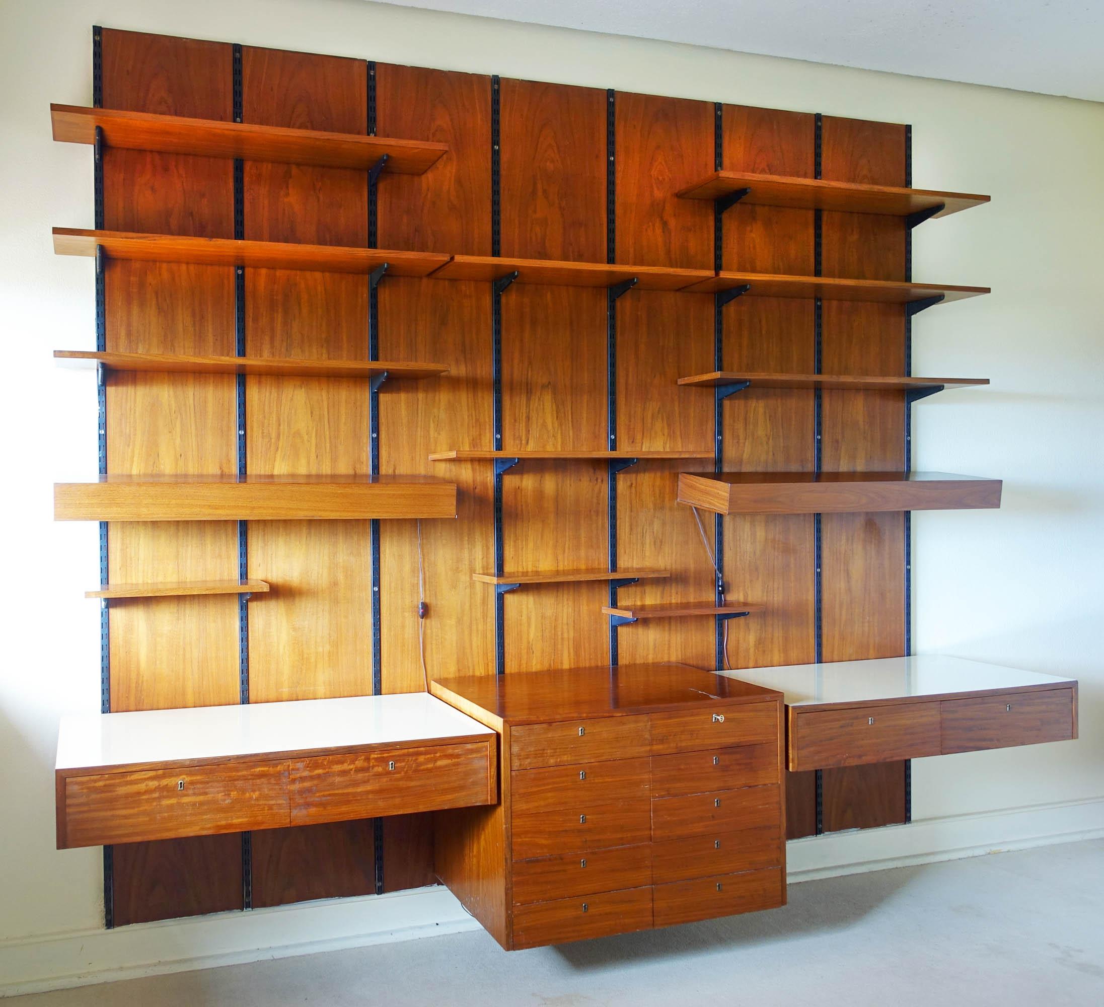 This wall unit was produced by Sparrings, in Sweden, during the 1960's. 
the wall unit consists of separate parts. There are three drawer blocks, two of them can be used as a desk. 
The shelves can be hung anywhere in the wall panel.
There