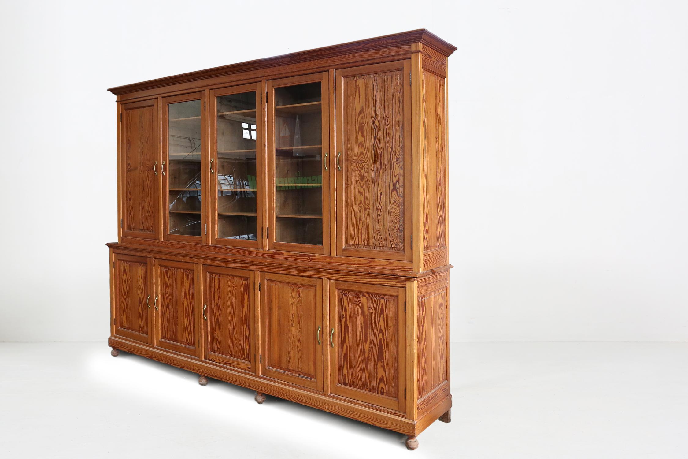 Large French monastery bookcase Ca.1870
The three large glass doors in the middle of the bookcase can be used as a display.
The beautiful wood structure of the pine wood provides a warm appearance.
This bookcase is finished with beautiful copper