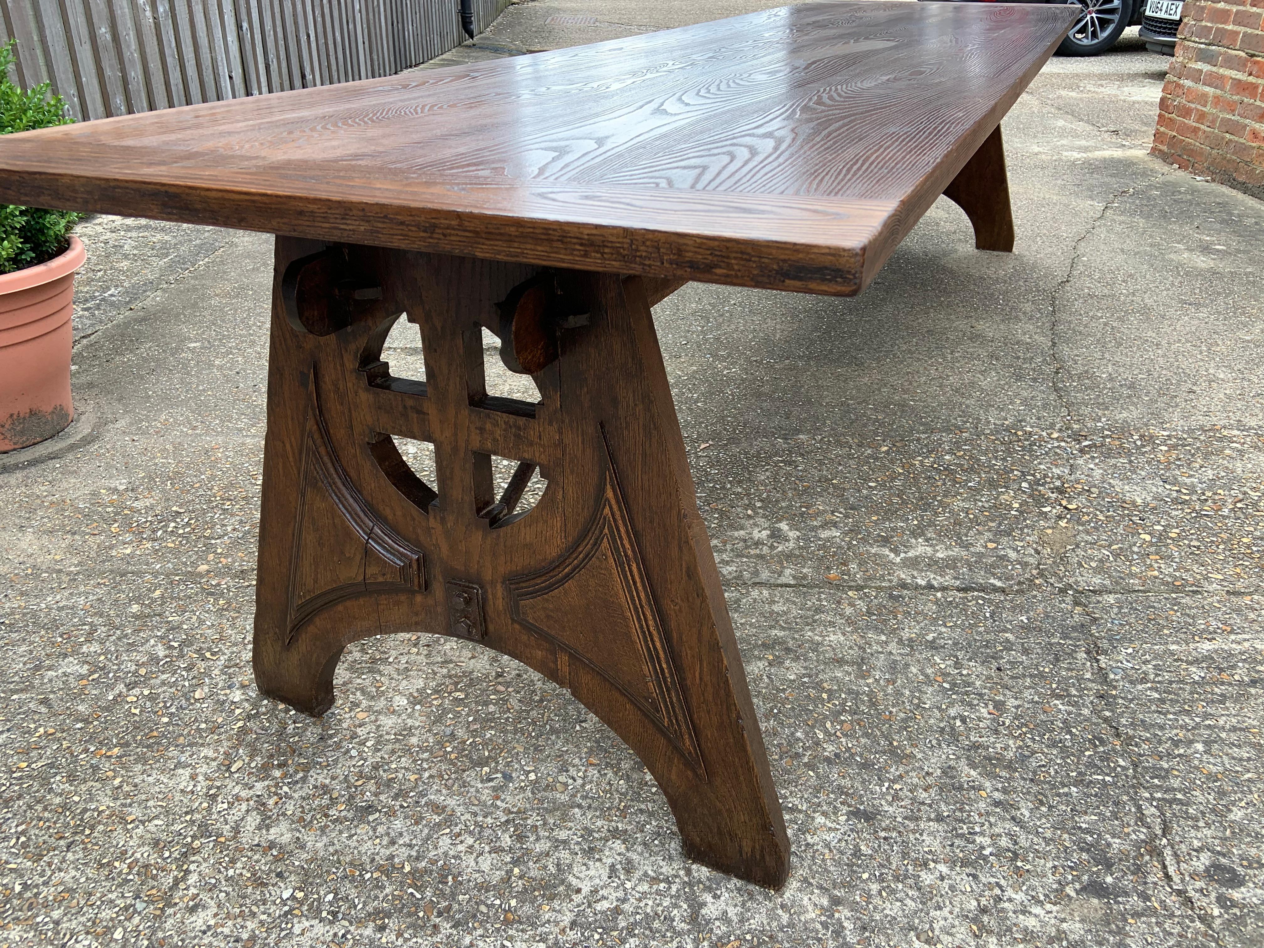 A large monastery table reputedly from Basilica de St Quentin, with a later stunning four plank textured top on pierced and angled trestle ends. 18th Century.
 