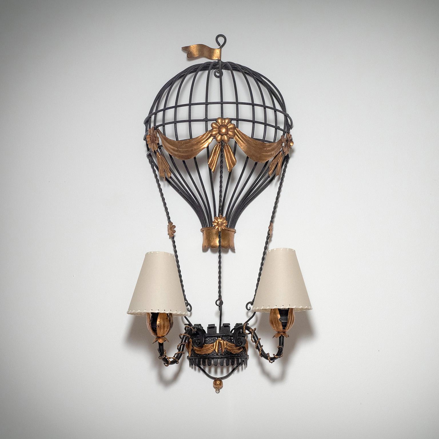 Very unique Italian wall light from the 1940-1950s in the shape of a Montgolfière (hot air ballon). Blackened forged iron with leaf metal decorations and new parchment-paper shades. Two original brass and ceramic E27 sockets with new