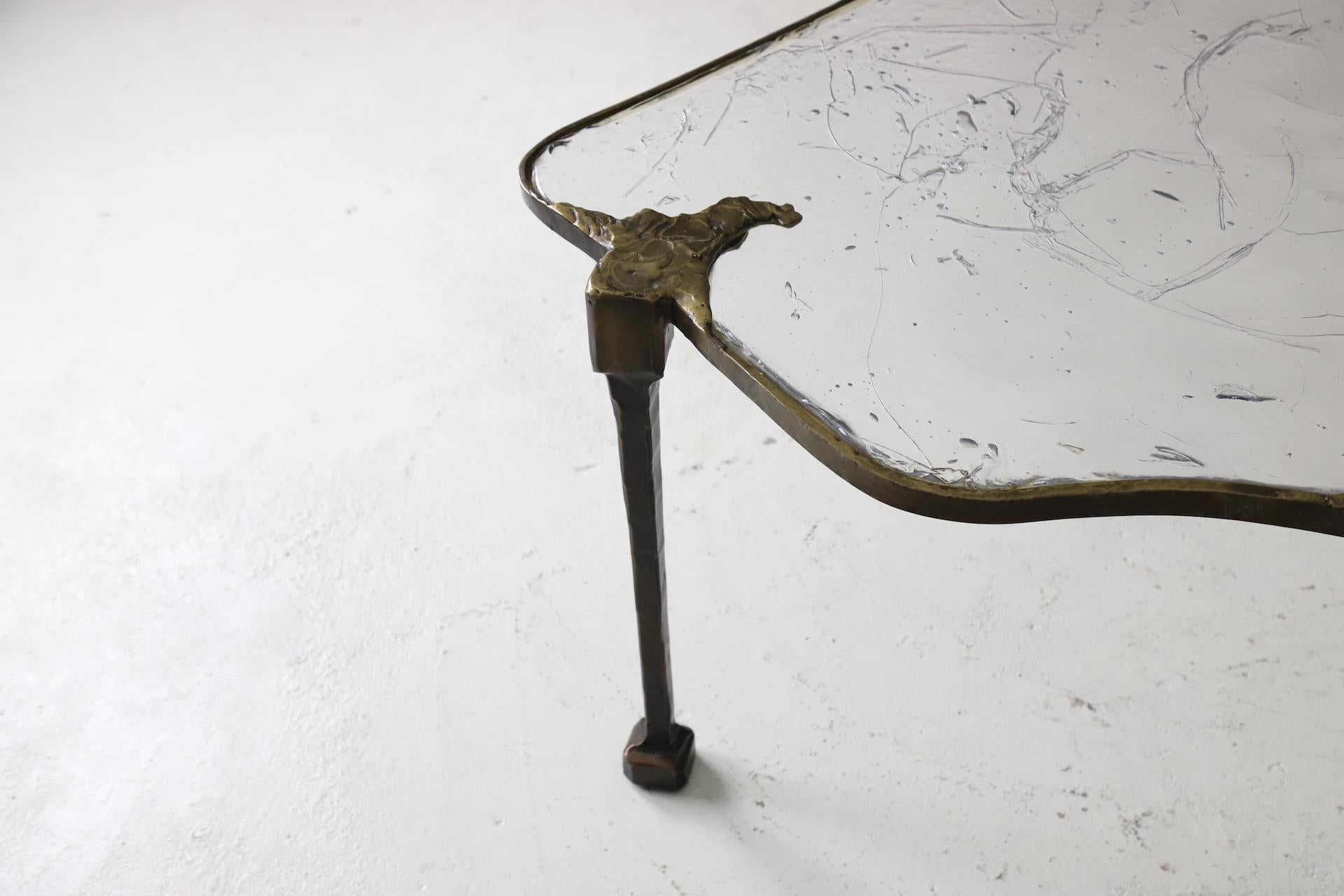 Großer monumentaler Couchtisch, entworfen von Lothar Klute. Dieser asymmetrische Tisch mit drei Beinen ist aus schwerer, geschmiedeter Bronze mit dicken, mundgeblasenen Glaseinlagen gefertigt. Signiert auf dem Sockel, LK '86. 
Kommt vom