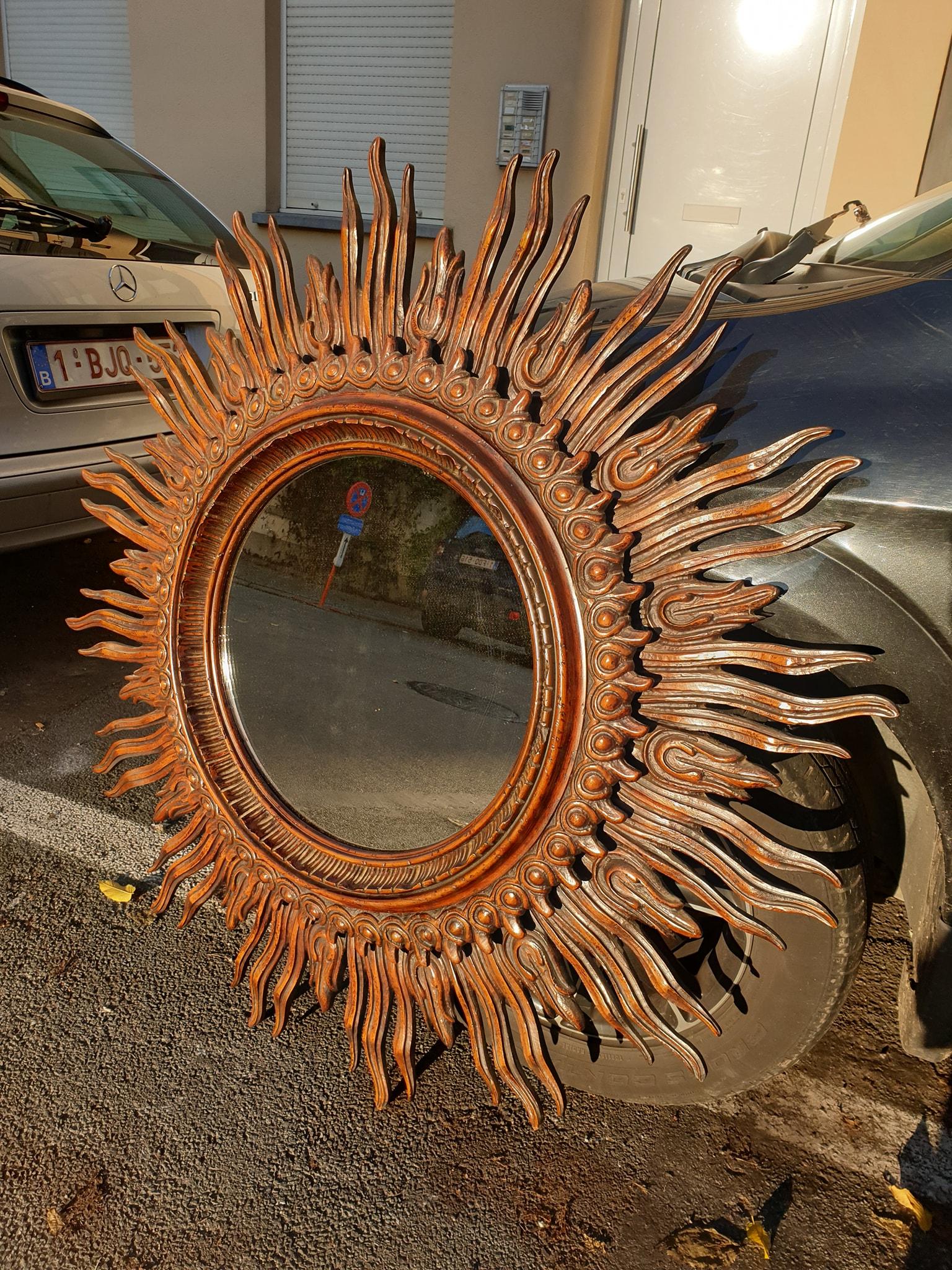 Sculptural finely carved round large sunburst mirror with a beautiful patina. Designed and manufactured by Francisco Hurtado, Valencia, Spain, 1950s. This mirror was handcrafted at the Mid-Century Modern period in the Hollywood Regency style.