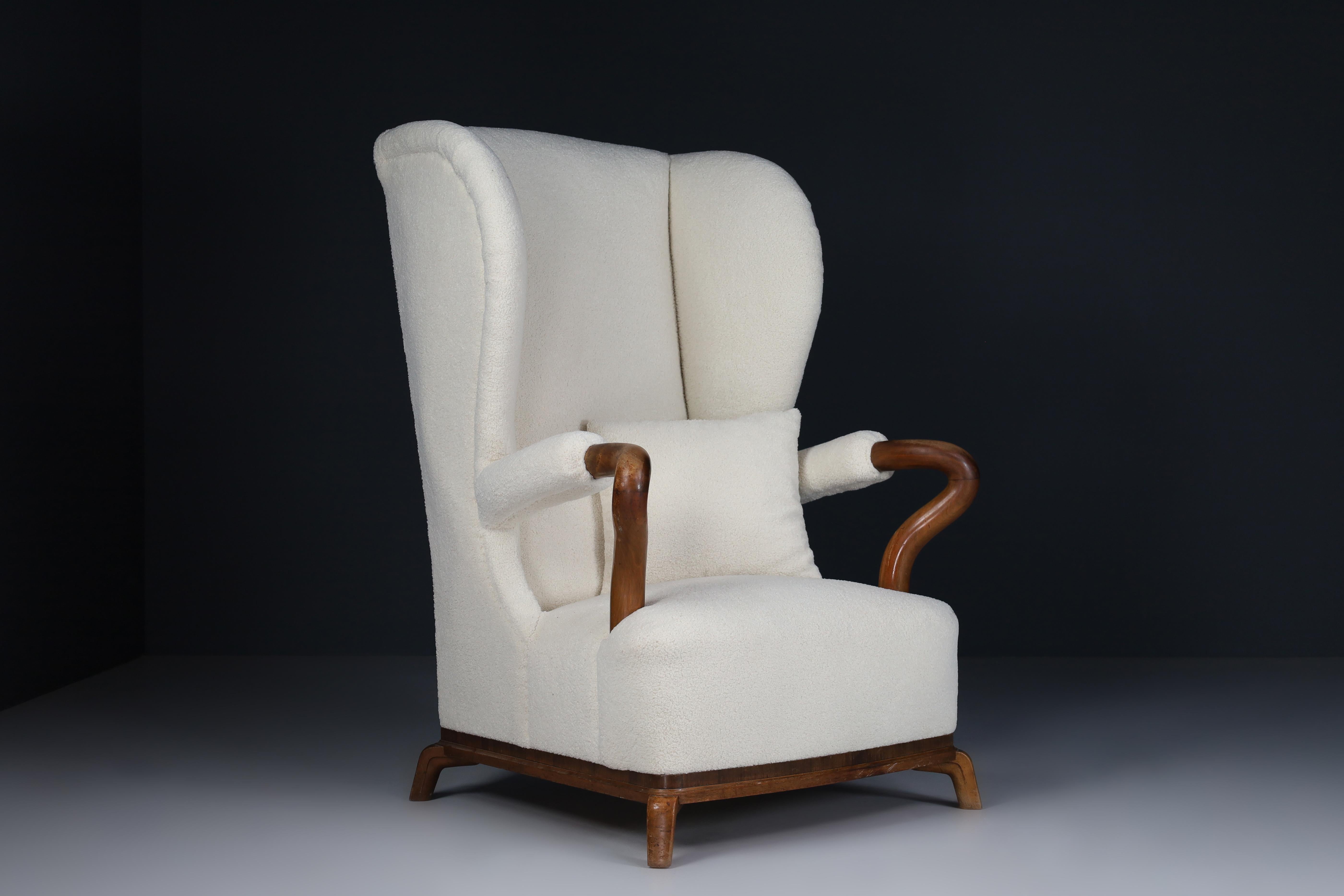 Large monumental midcentury wingback walnut armchair in re-upholstered teddy fabric, France 1930s. This large armchair would be an eye-catching addition to any interior, such as a living room, family room, screening room or office. It also perfectly