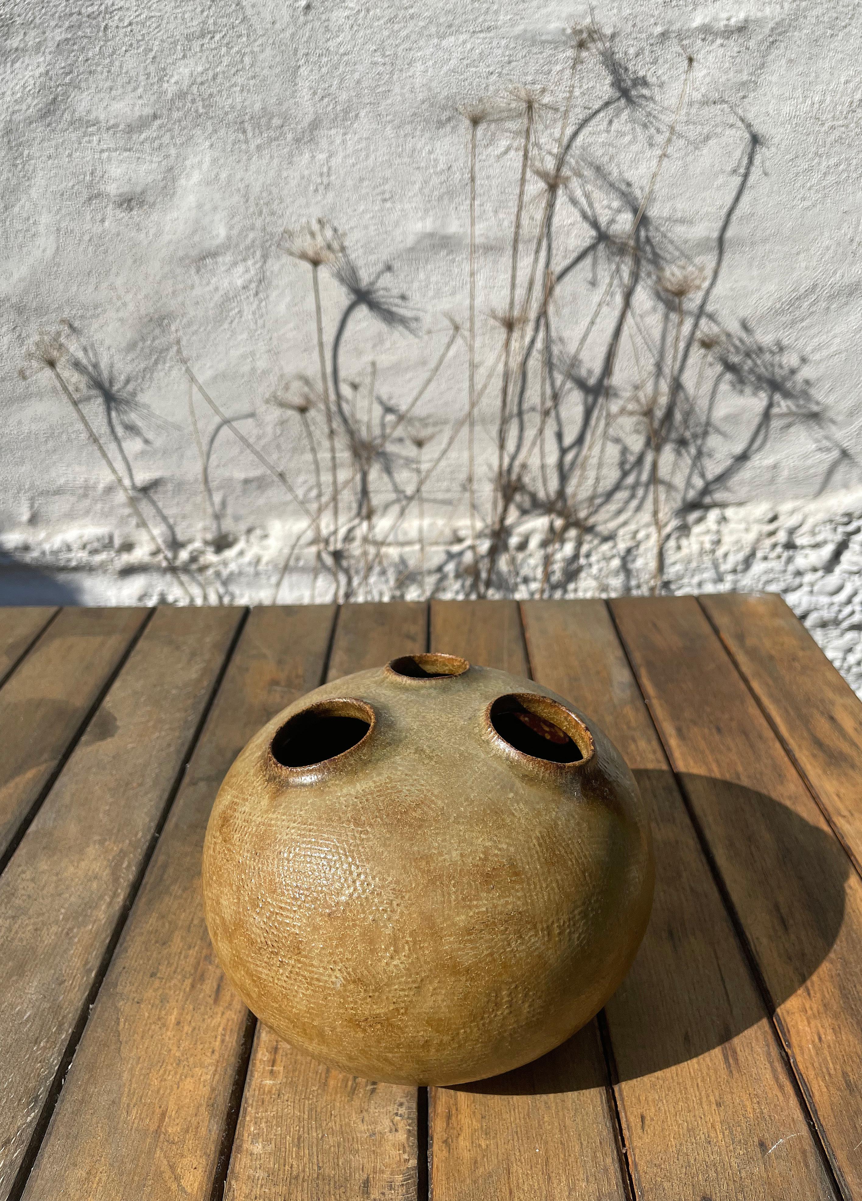 Glazed organic Mid-Century Modern tactile ceramic sculpture vase by Danish ceramic artist Kirsten Günther for Knabstrup in the early 1970s. Peanut brown earth colored glaze over handmade graphic relief imprints with three circular openings for