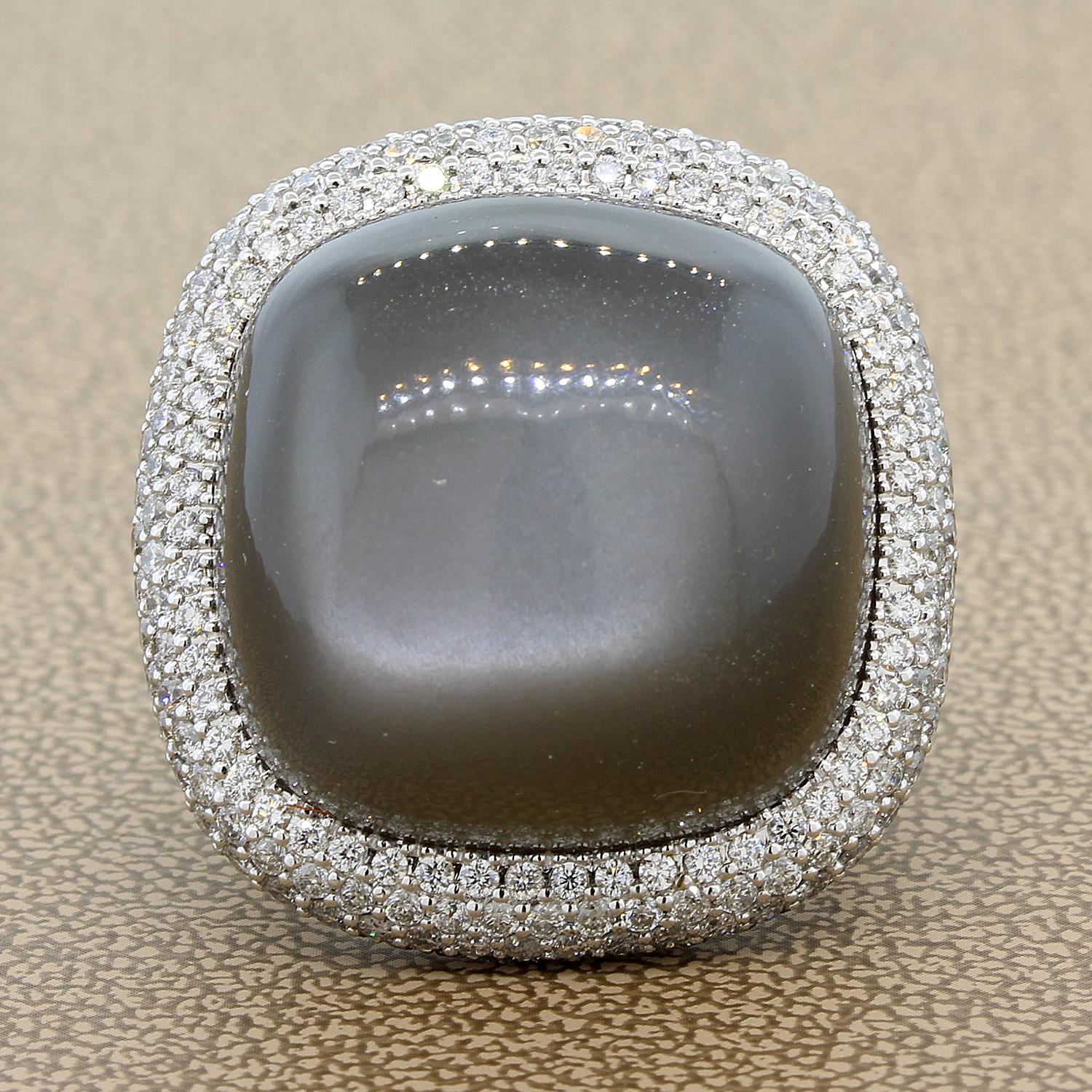 An impressive cocktail ring featuring an impressive moonstone weighting 55.70 carats. Accenting the center stone are 6.11 carats of round cut diamonds covering the entire ring. Set in 18K white gold. 
A bold look for a woman who knows what she