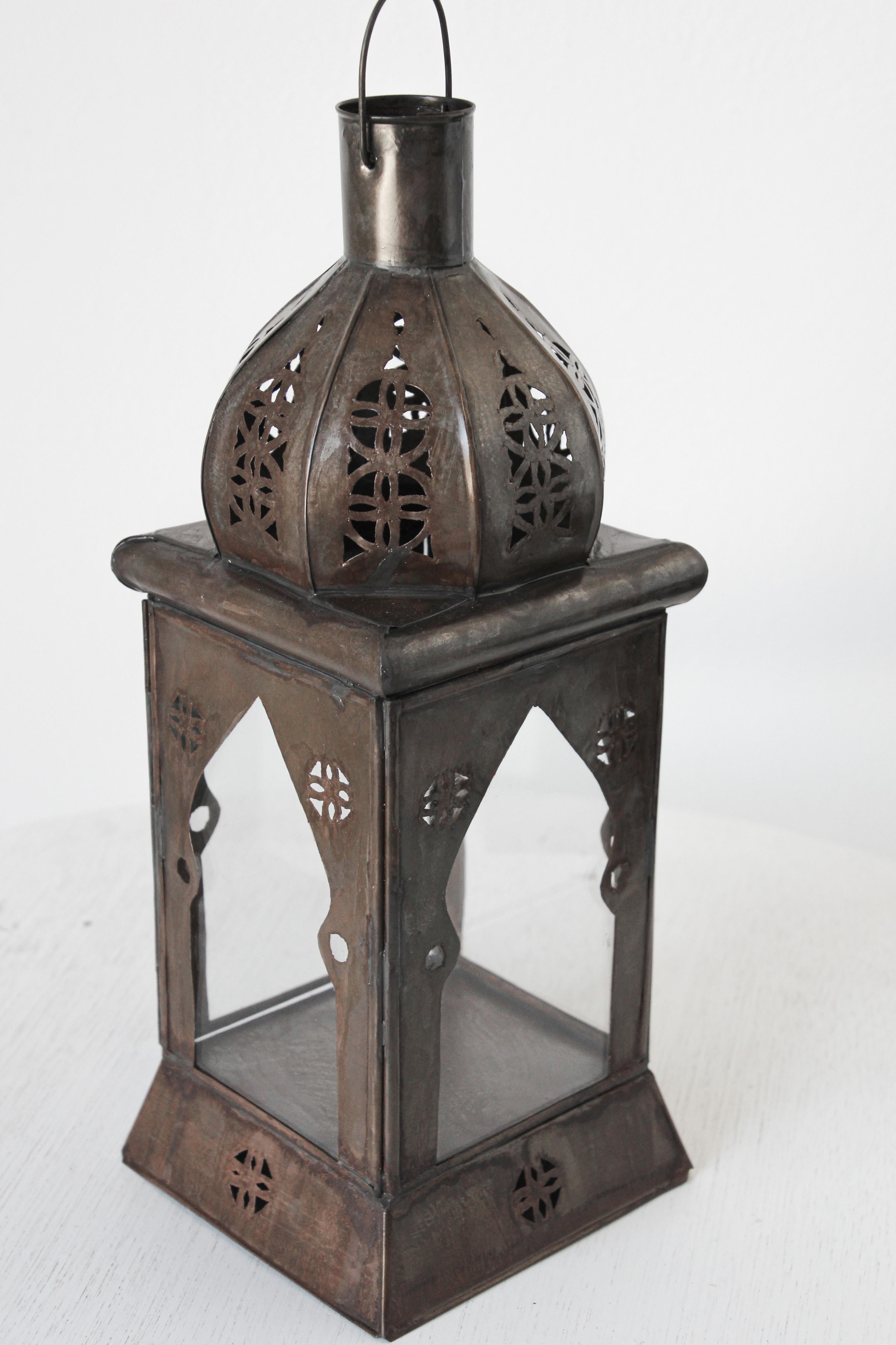 Small handcrafted Moroccan clear glass lantern adorned with open metal work Moorish filigree design.
Hurricane tole candle lamp with open metal work design and clear glass.
For indoor or covered area use only.
Many of our customers place oil candles