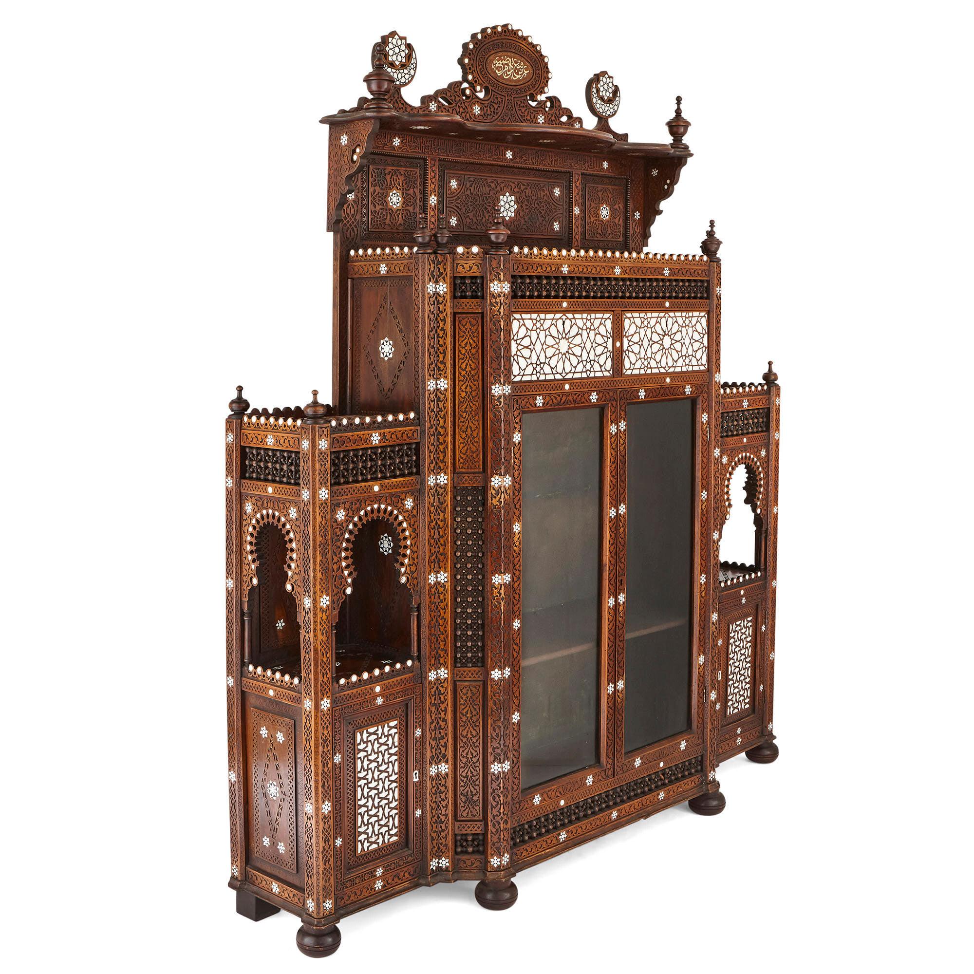 Produced in Syria during the late 19th century, this large cabinet is designed about a tripartite structural scheme. The cabinet features a tall centre that is flanked by two smaller cupboards, the whole unit standing upon a combination of bun and