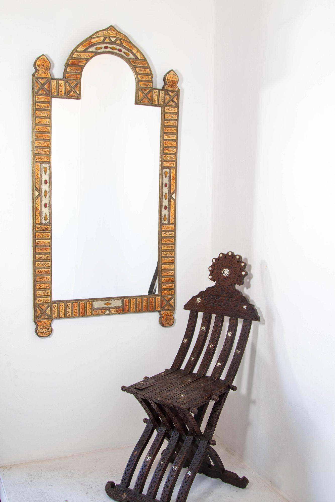 Large Moroccan mirror with brass embossed metal.
Vintage Moroccan handcrafted inlay bone and brass arched Moorish wall mirror.
Moroccan mirror inlaid with carved recycled bone and brass embossed metal, intricately worked with classic elements of