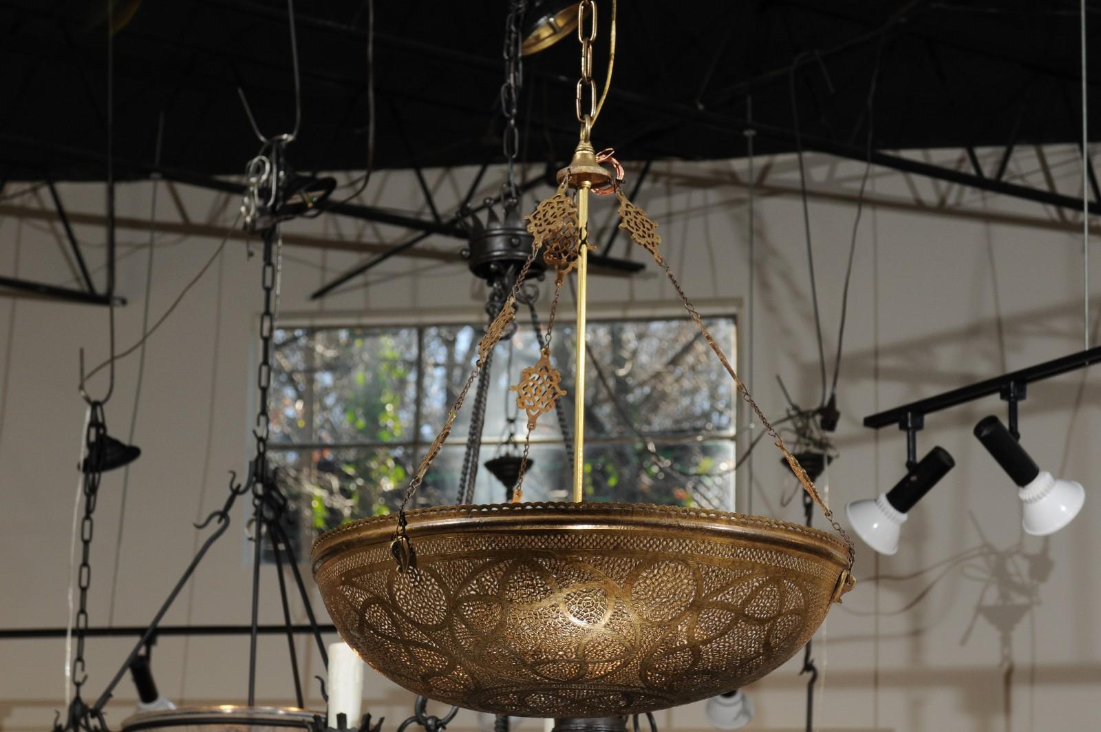 A large Moorish style brass dome pendant light fixture from Morocco with pierced geometrical patterns, 20th century. Born in North Africa during the early years of the 20th century, this large dome light fixture showcases an opulent decor typical of