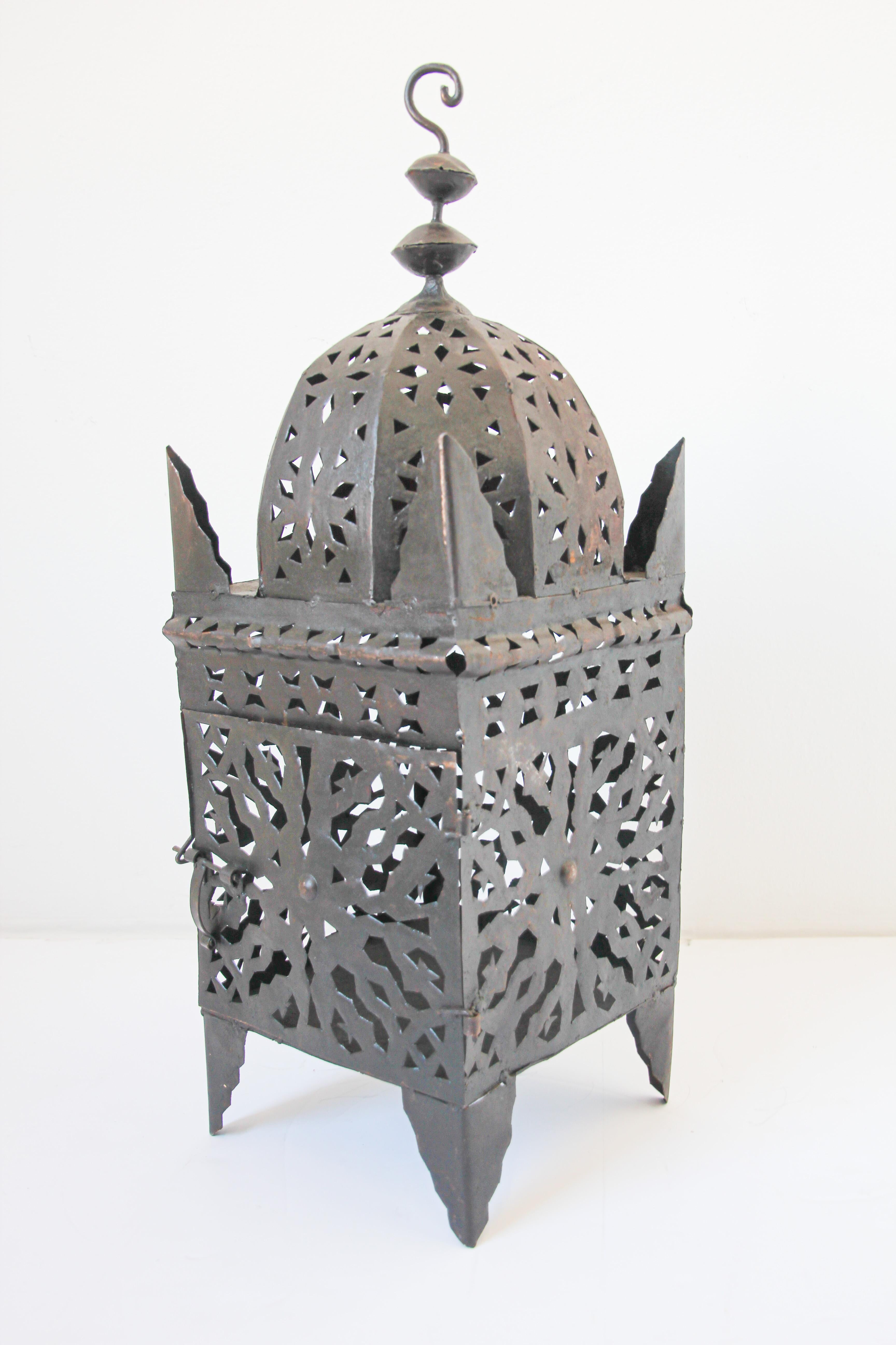 Large Moroccan Moorish metal candle lantern.
Hurricane candle lamp handcrafted in Morocco by artisans, metal hand-cut openwork hammered with Moorish design, open in front for use with pillar candles.
The lantern has a small door to access the