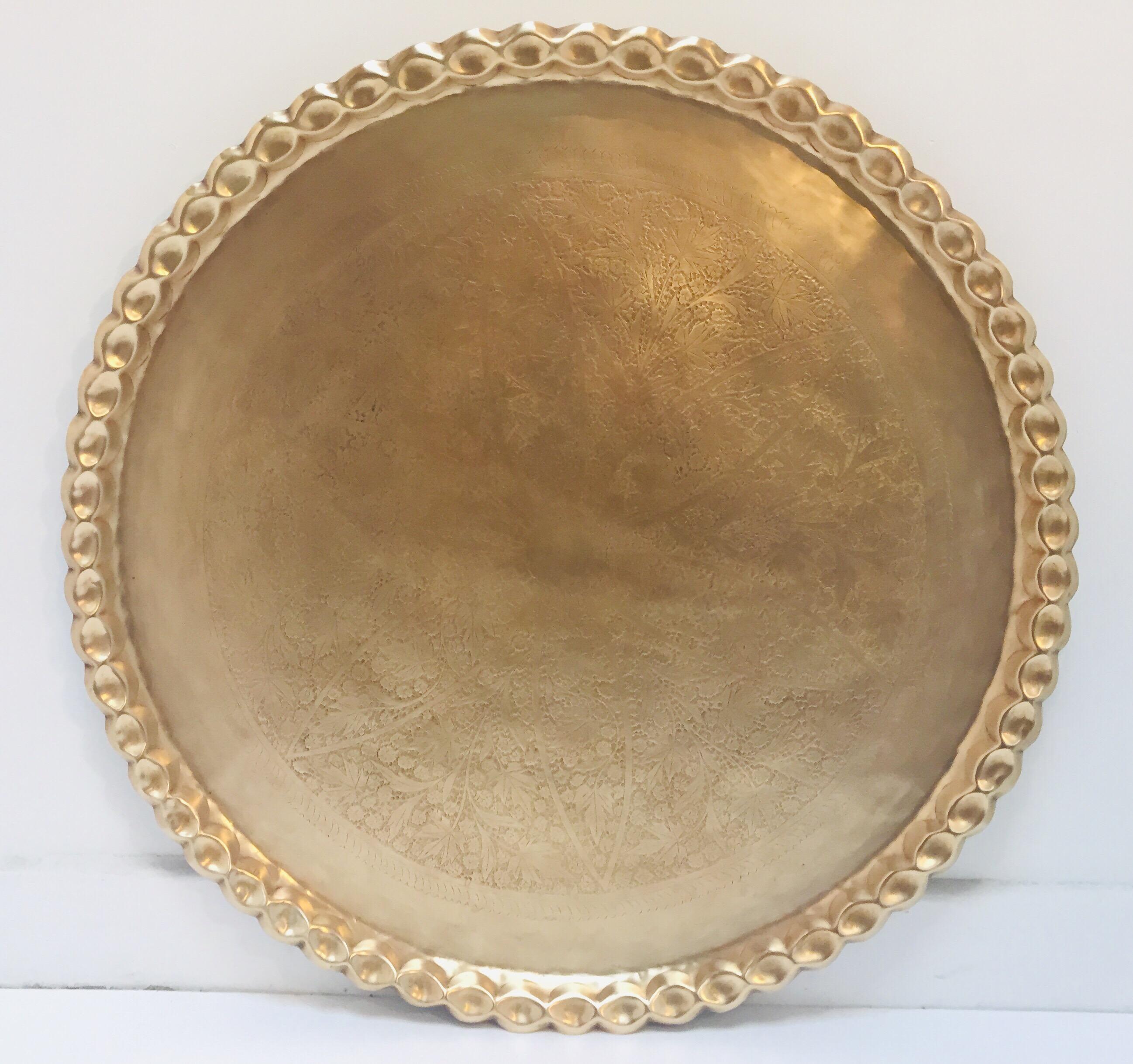 Large Moroccan round brass tray table on folding stand.
Engraved and embossed large 40 inches round midcentury Moroccan brass tray table.
Polished brass Moroccan tray, very good condition, standing on folding metal base.
Very hard to find 40