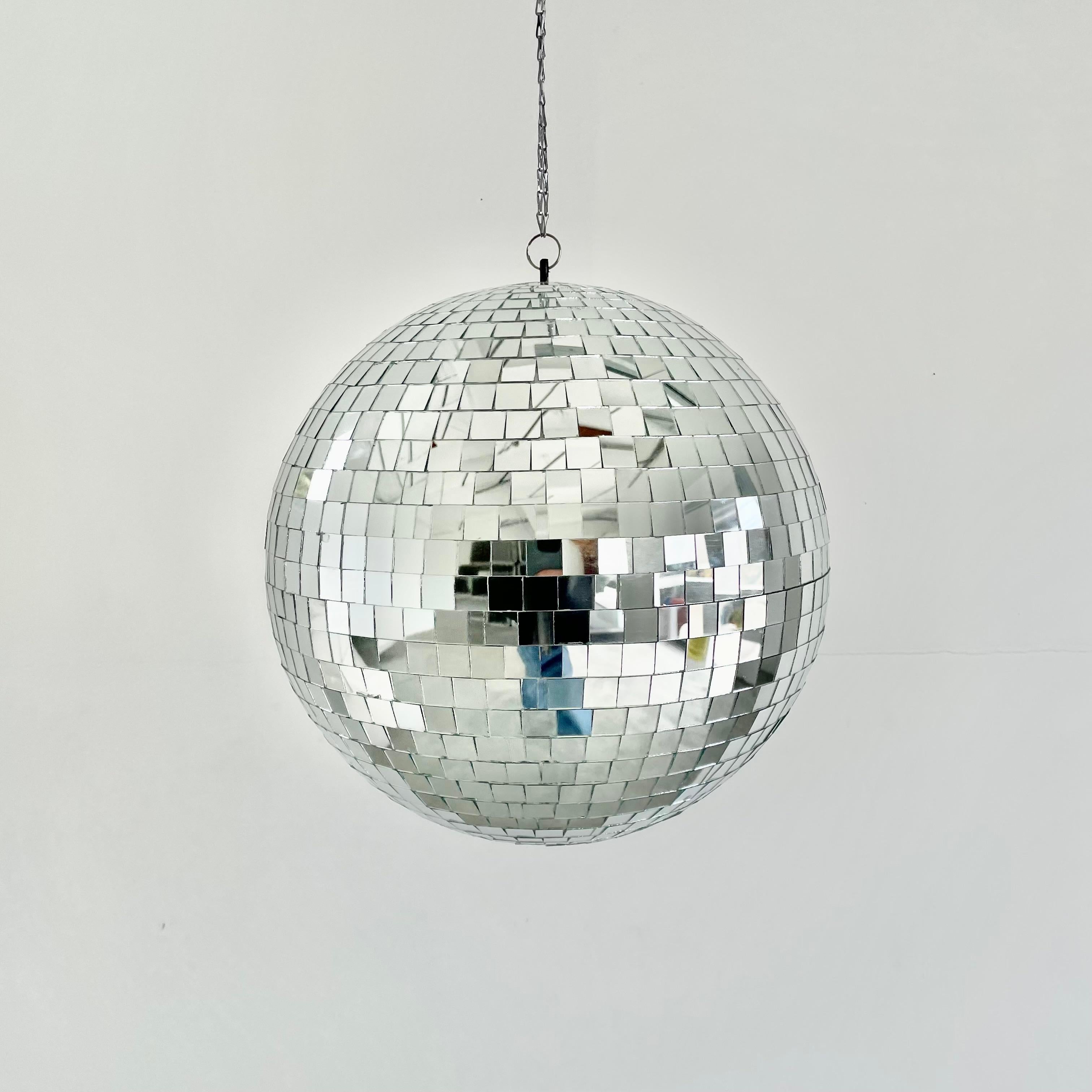 Large retro disco ball made out of individually cut square pieces of glass in a larger size than normal giving it a great look. Good condition. Illuminates beautifully. Has a metal ring at the top which is connected to a 3 foot long silver chain