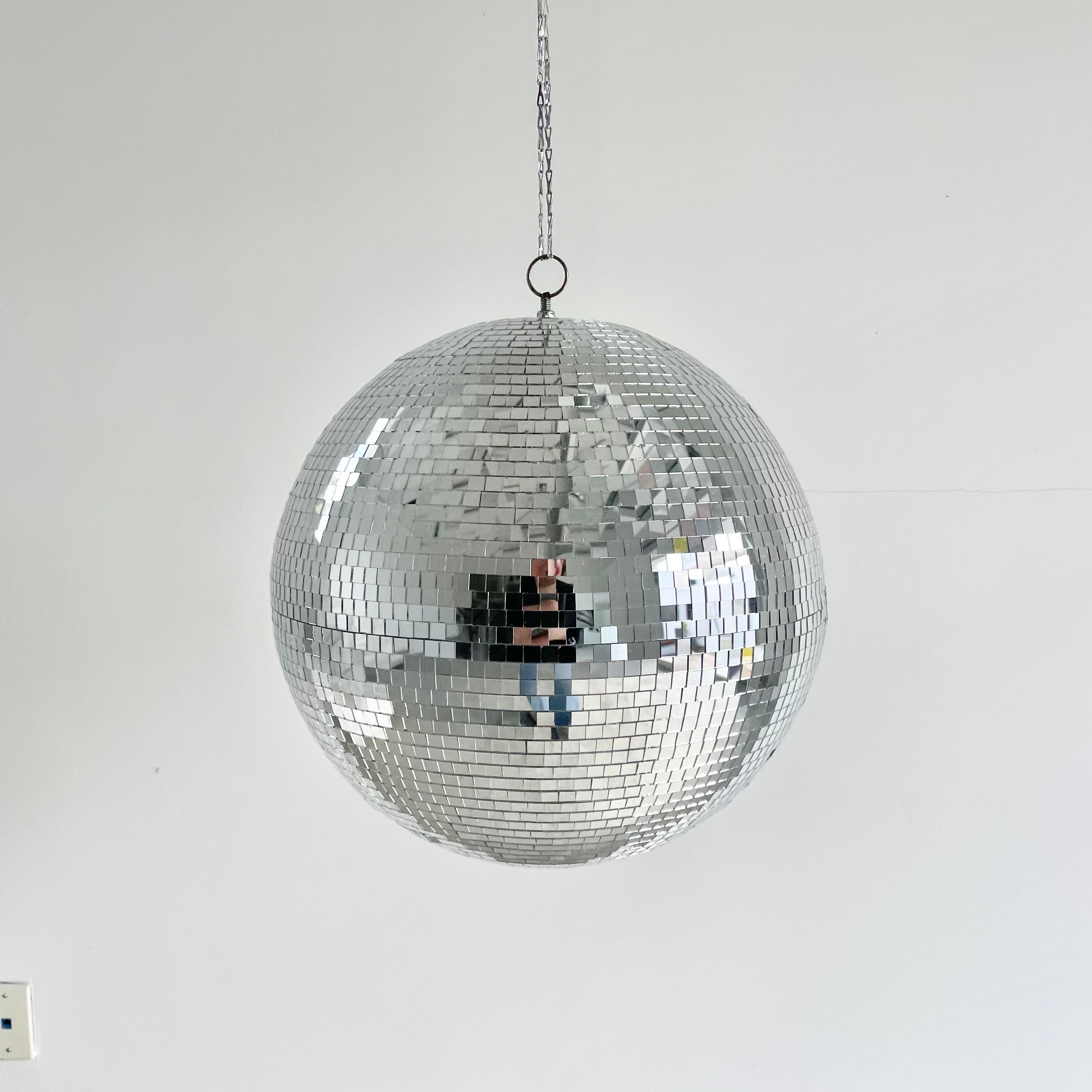 Large retro disco ball made out of small individually cut square pieces of glass. Great condition. Illuminates beautifully. Has a metal ring at the top which is connected to a 3 foot long silver chain link which can be taken off if desired. Uncommon