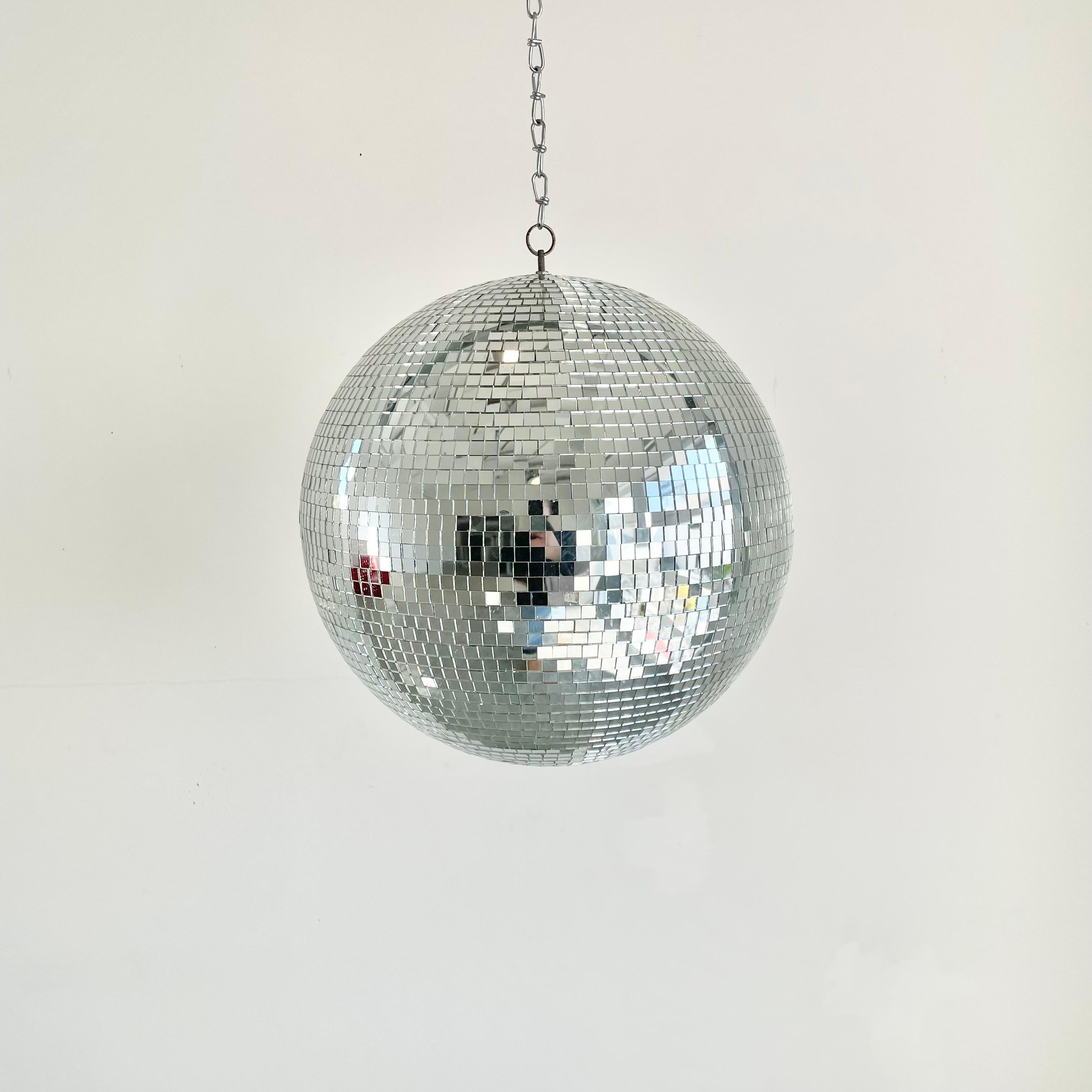 Large retro disco ball made out of small individually cut square pieces of glass giving it a great look. Good condition. Illuminates beautifully. Has a metal ring at the top which is connected to a 1.5 foot long silver chain link which can be taken