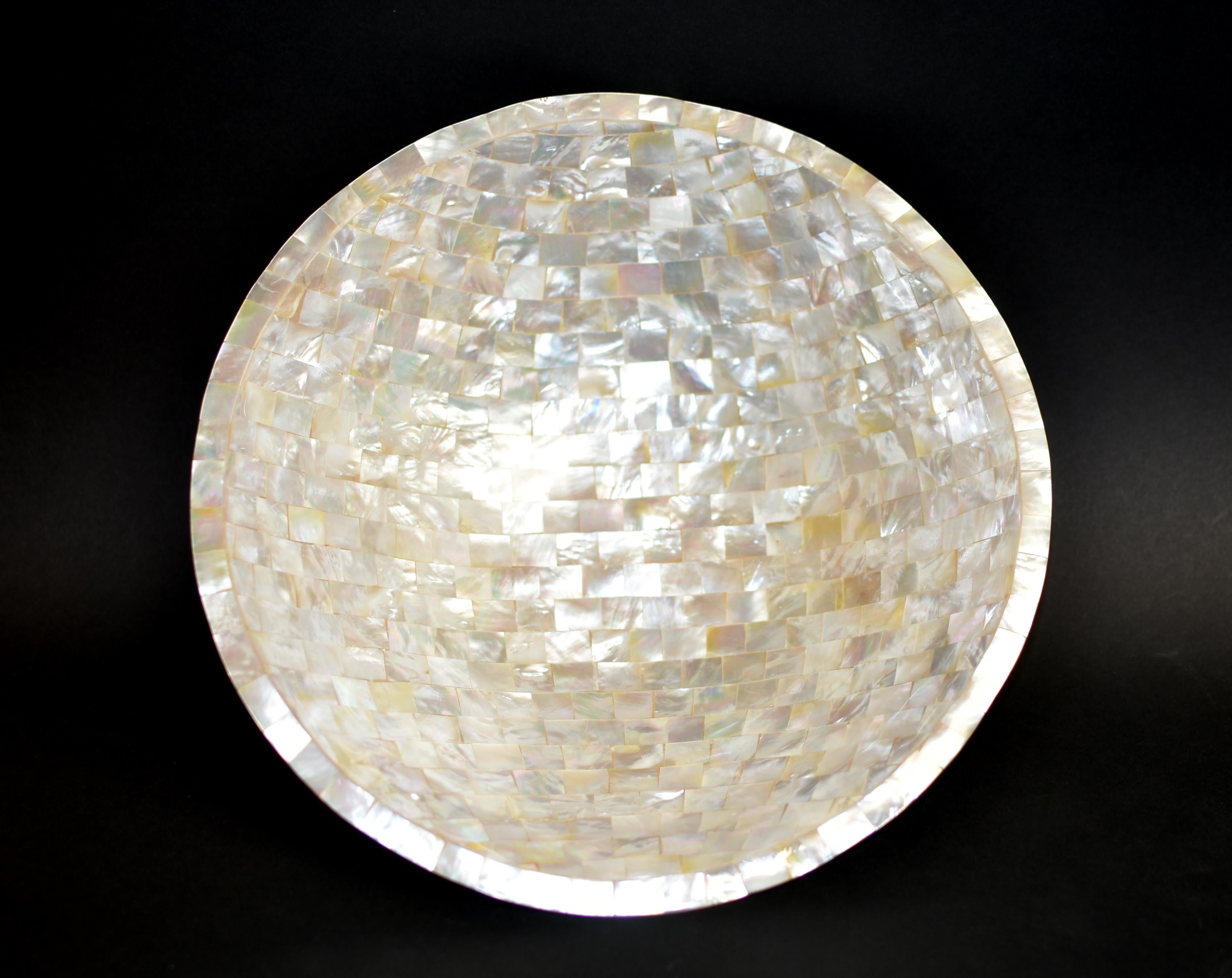 A spectacular mother of pearl bowl, completely hand made by the Indonesian craftsmen. Bowl is meticulously encrusted with mother of pearl and polished to a beautiful, lustrous shine. Perfectly smooth to touch, iridescent inside out and all around.