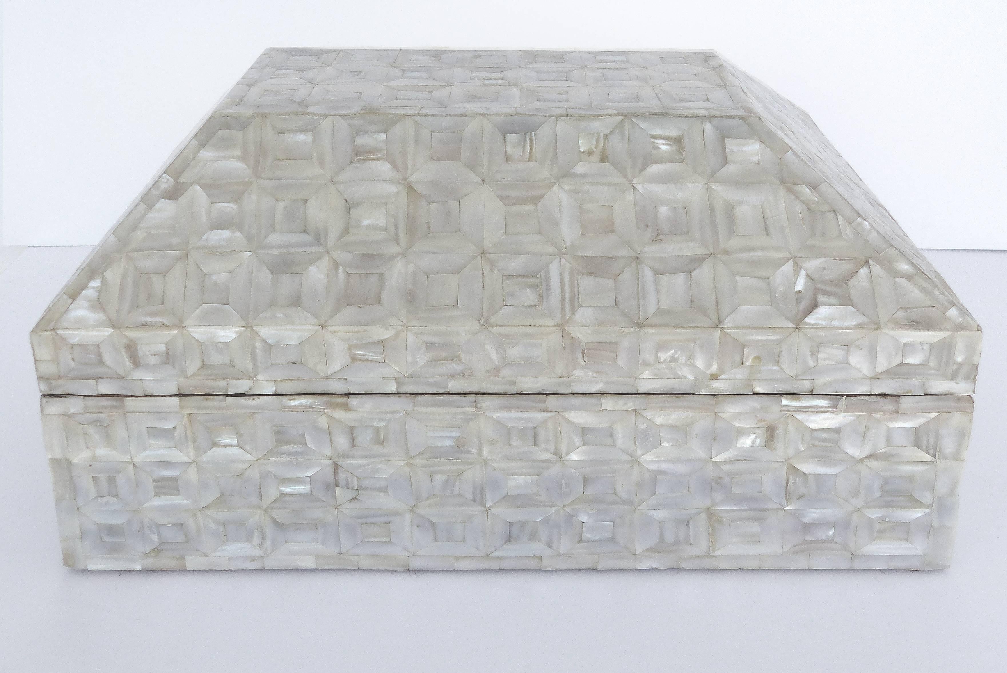 Offered for sale is a large mother-of-pearl tessellated wood hinged box. Possibly from the Phillipines, this box has an intricate inlay pattern and it has a coffered form lid.