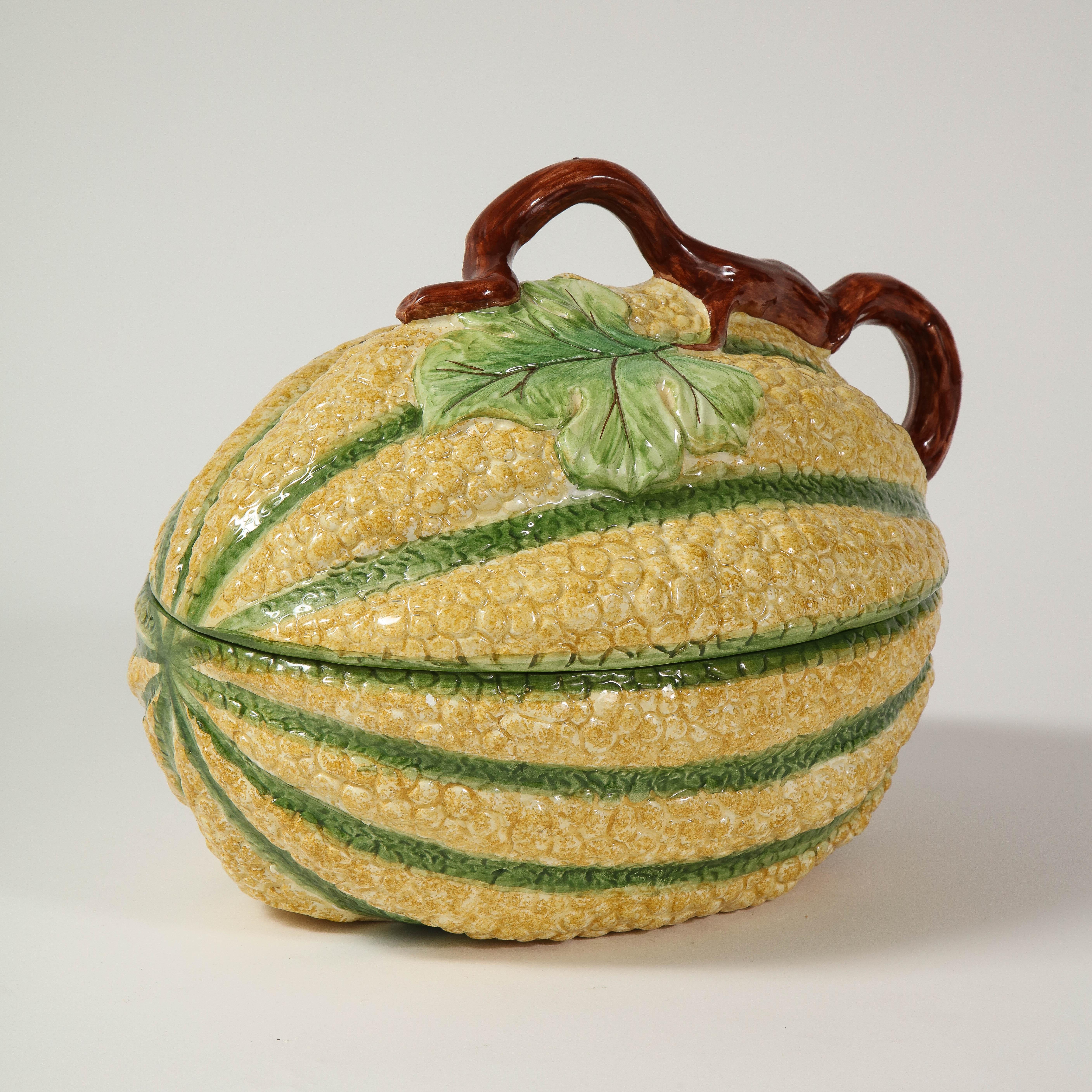 Painted yellow with green stripes; the removable lid surmounted by a vine-form finial; the interior glazed white. Marked 