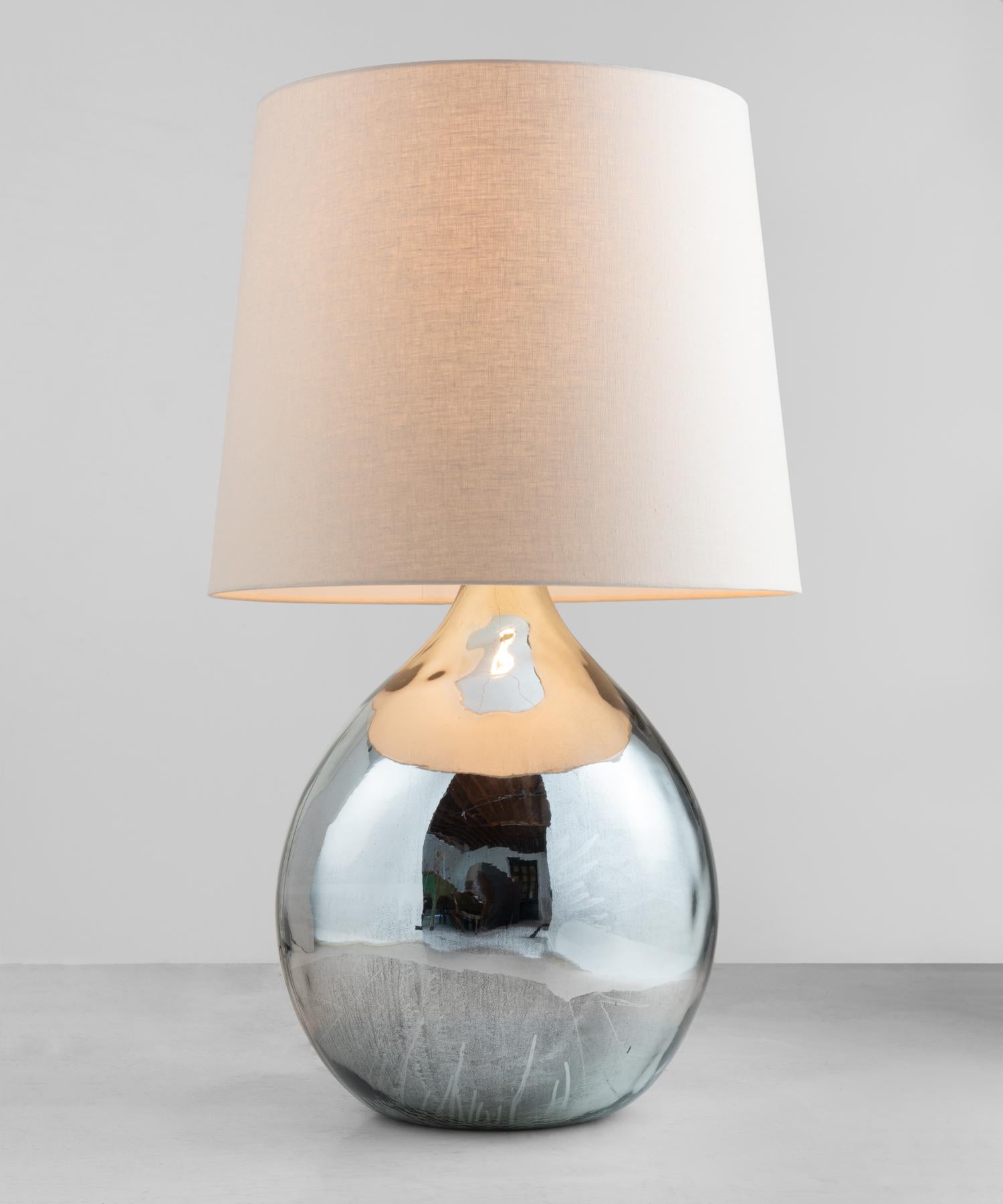 Large mottled mirrored lamp, England, circa 1940.

Originally used as a chemical storage bottle with incredible patina and surface. New linen shade.

Measure: 24