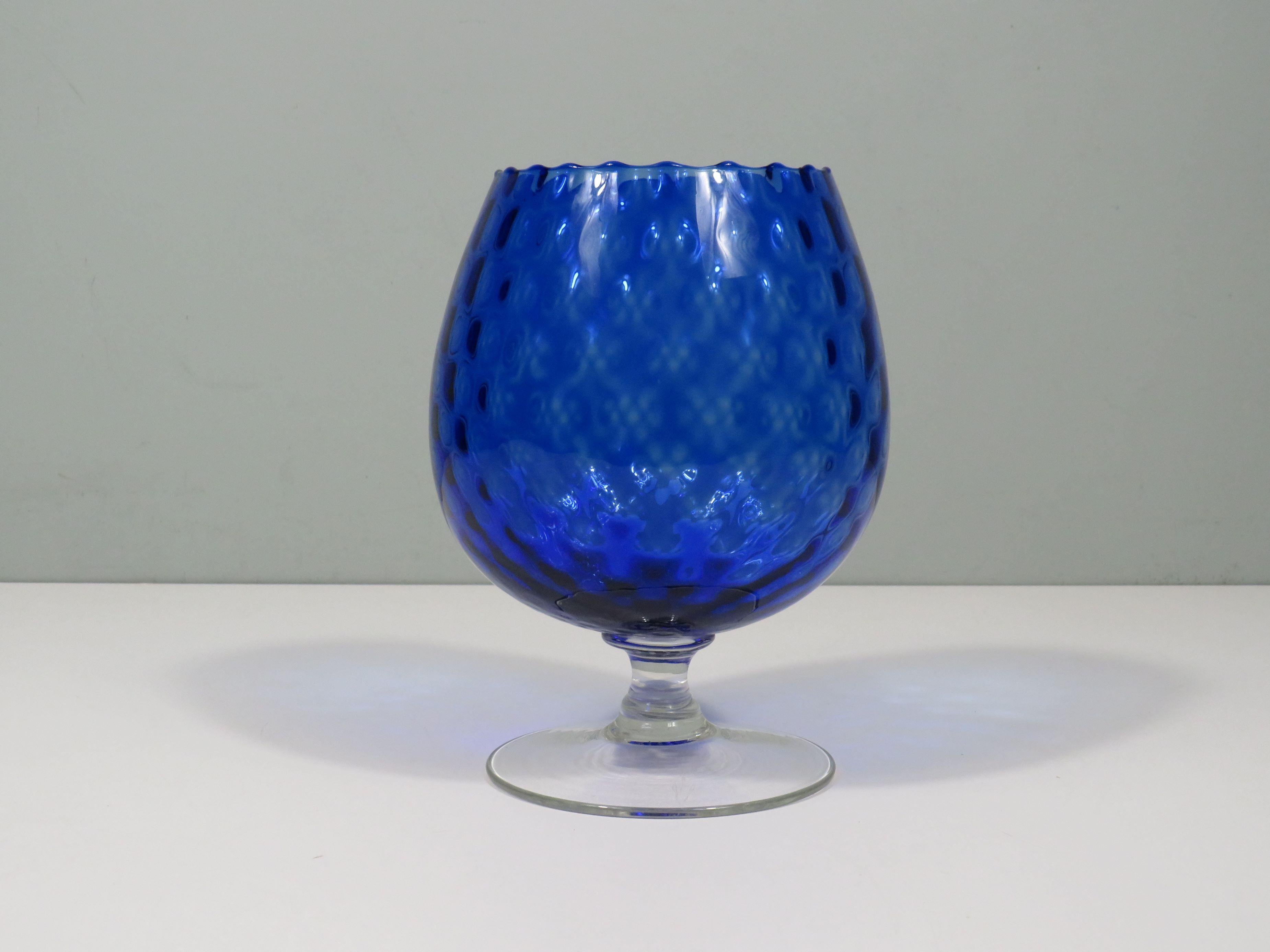 Questo lussuoso bicchiere di Empoli soffiato a bocca aggiungerà un elegante tocco di colore a qualsiasi ambiente. Sia che venga utilizzato come oggetto decorativo, centrotavola o parte di un tableau decorativo, il ricco colore blu e il bellissimo