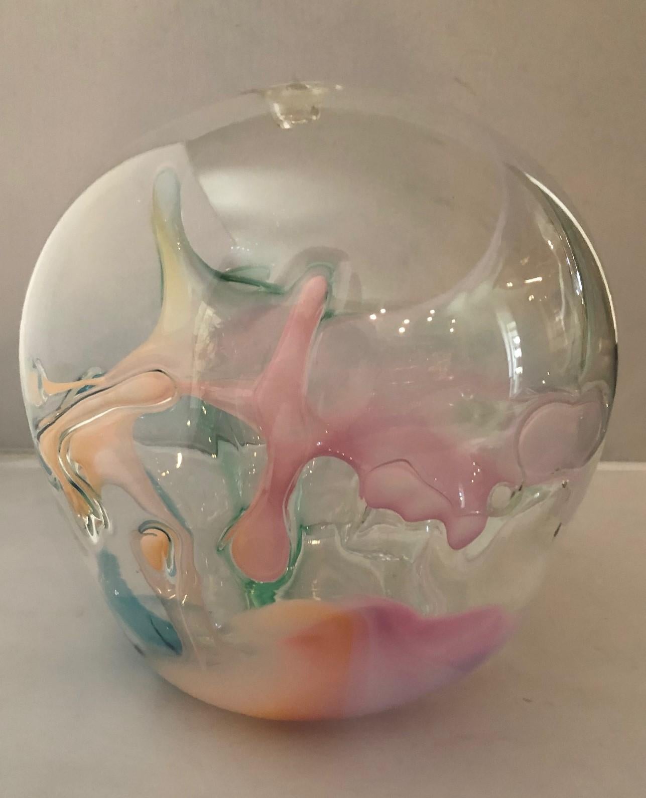 Grande sculpture en verre d'art multicolore de Peter Bramhall, vers 1983. Cette sculpture orbe en verre soufflé à la main présente des fils de verre internes de couleur rose, blanche et verte. La pièce mesure environ 10