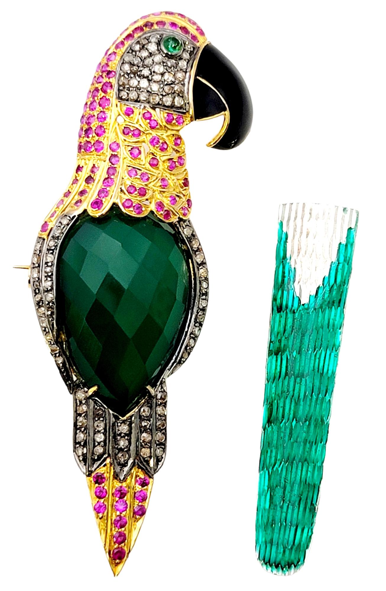 Fabulously bold macaw brooch / pendant bursting with personality! This beautifully detailed bird brooch is filled with glittering diamonds and colorful gemstones including pink sapphires, chalcedony and emerald. The green enamel tail can be easily
