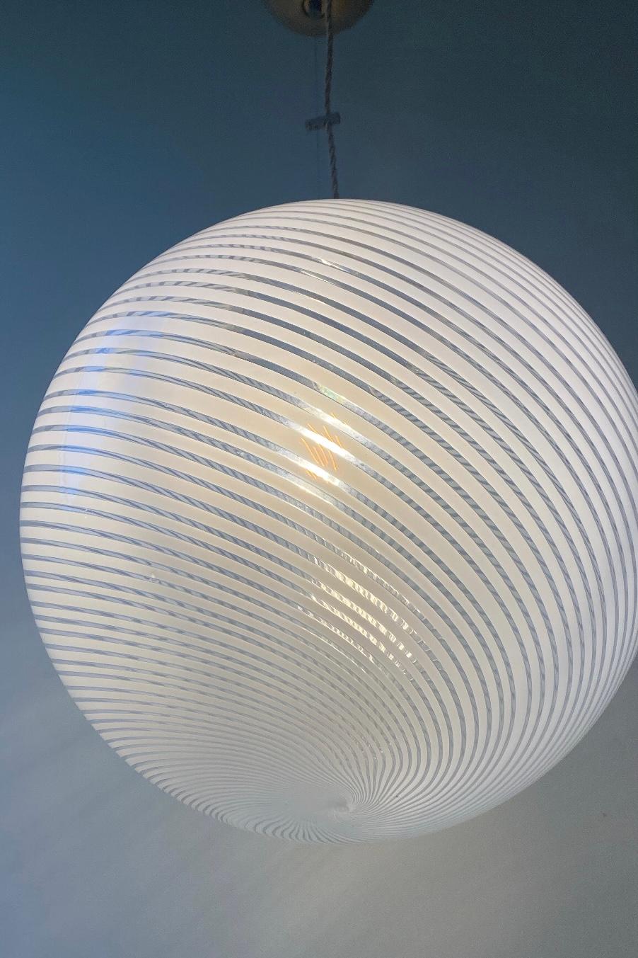 Vintage Murano filigrana ceiling lamp / pendant in transparent glass with white swirl. Gives the finest pattern on the wall when the sun is on as well as when it is on. Handmade in Italy, 1960/70s, and has adjustable brass suspension. Measure: D: 40