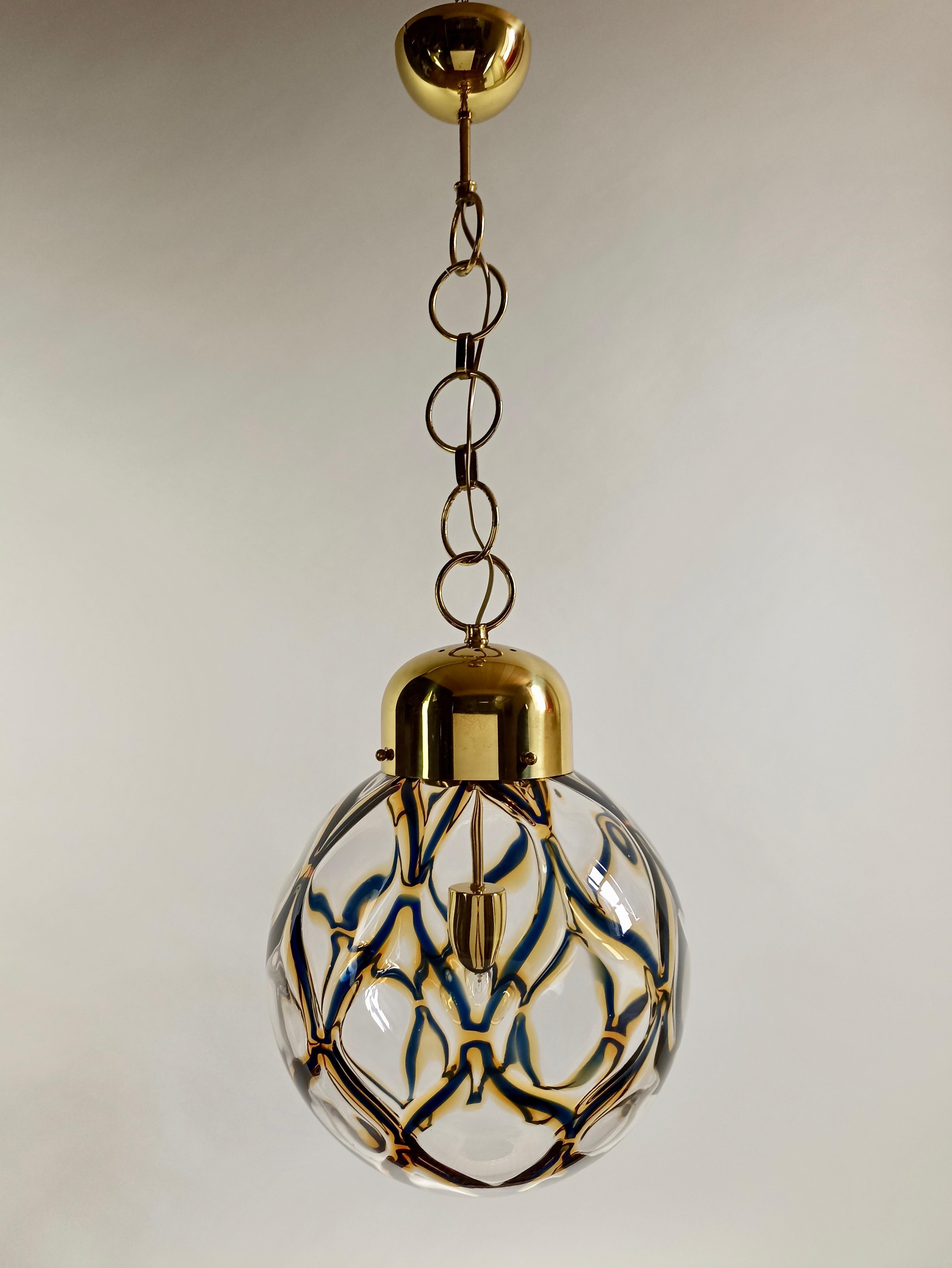 Charming and rare Italian Space Age 1970s Toni Zuccheri attributable Murano pendant lamp, in clear hand-blown art glass with a yellow and blue pattern to create a cage-like design reminiscent of Venetian lanterns.
Gilded metal frame.
Weight: 4,6