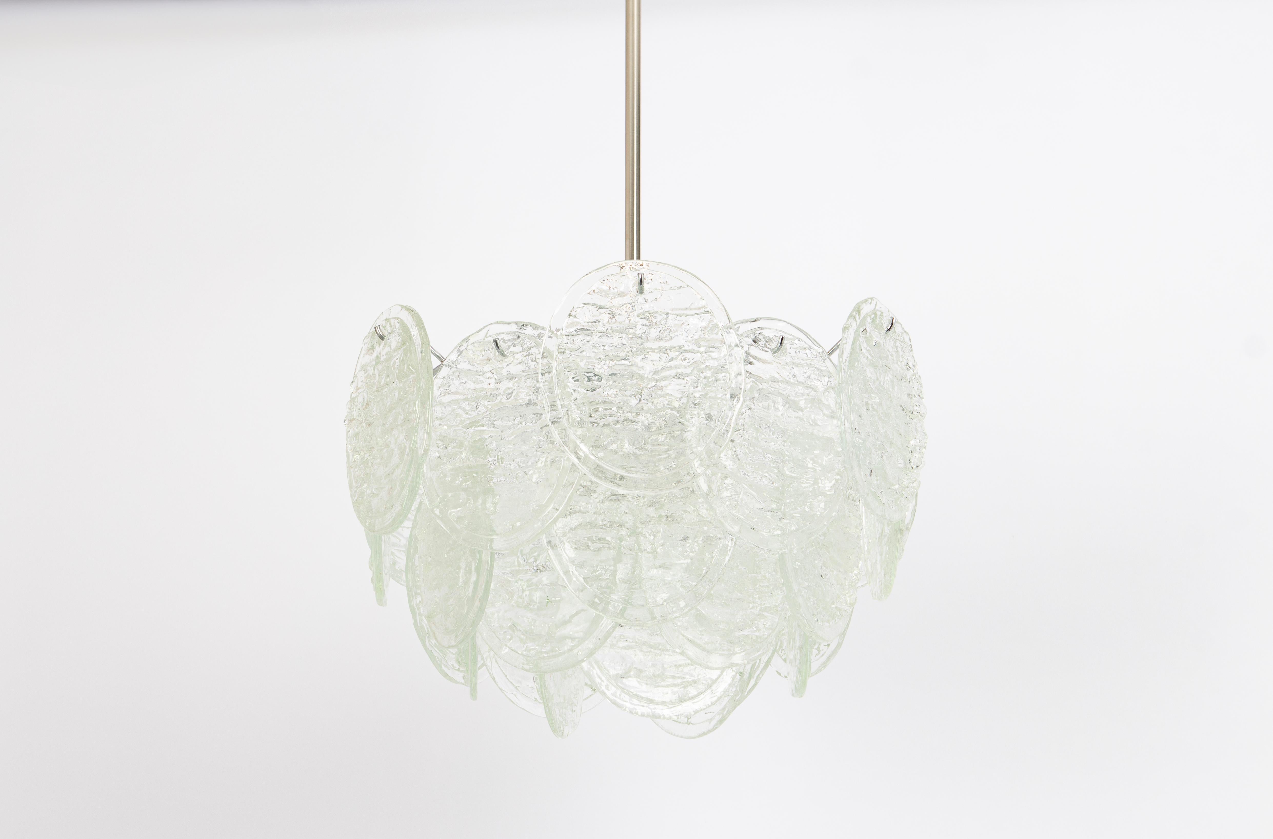 Superbe lustre en verre de Murano par Kalmar, années 1960
Une structure à trois niveaux rassemblant 27 verres en forme de disques et de feuilles est suspendue à un cadre en fil de fer nickelé, réfractant magnifiquement la lumière.

De haute qualité